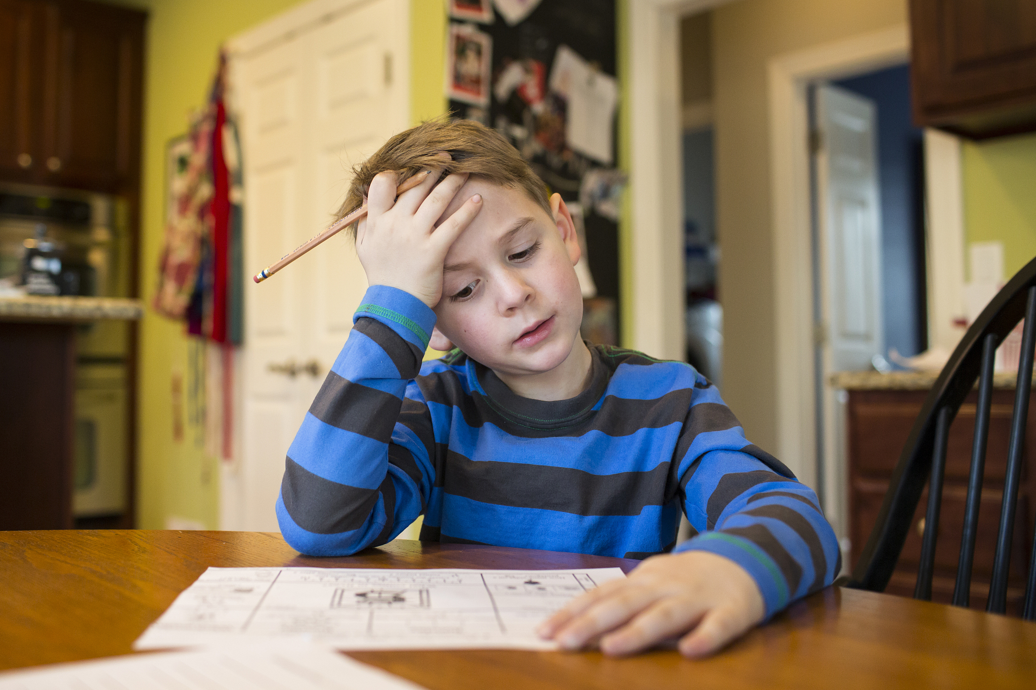 boy studying by table at home