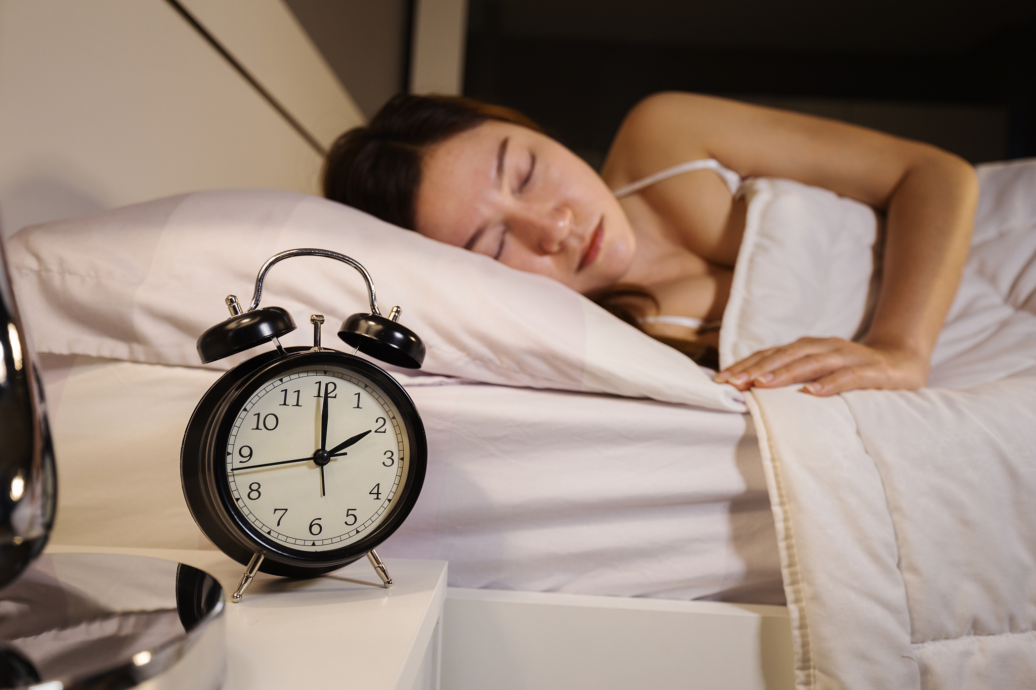 clock show 2 o'clock and woman sleeping on bed