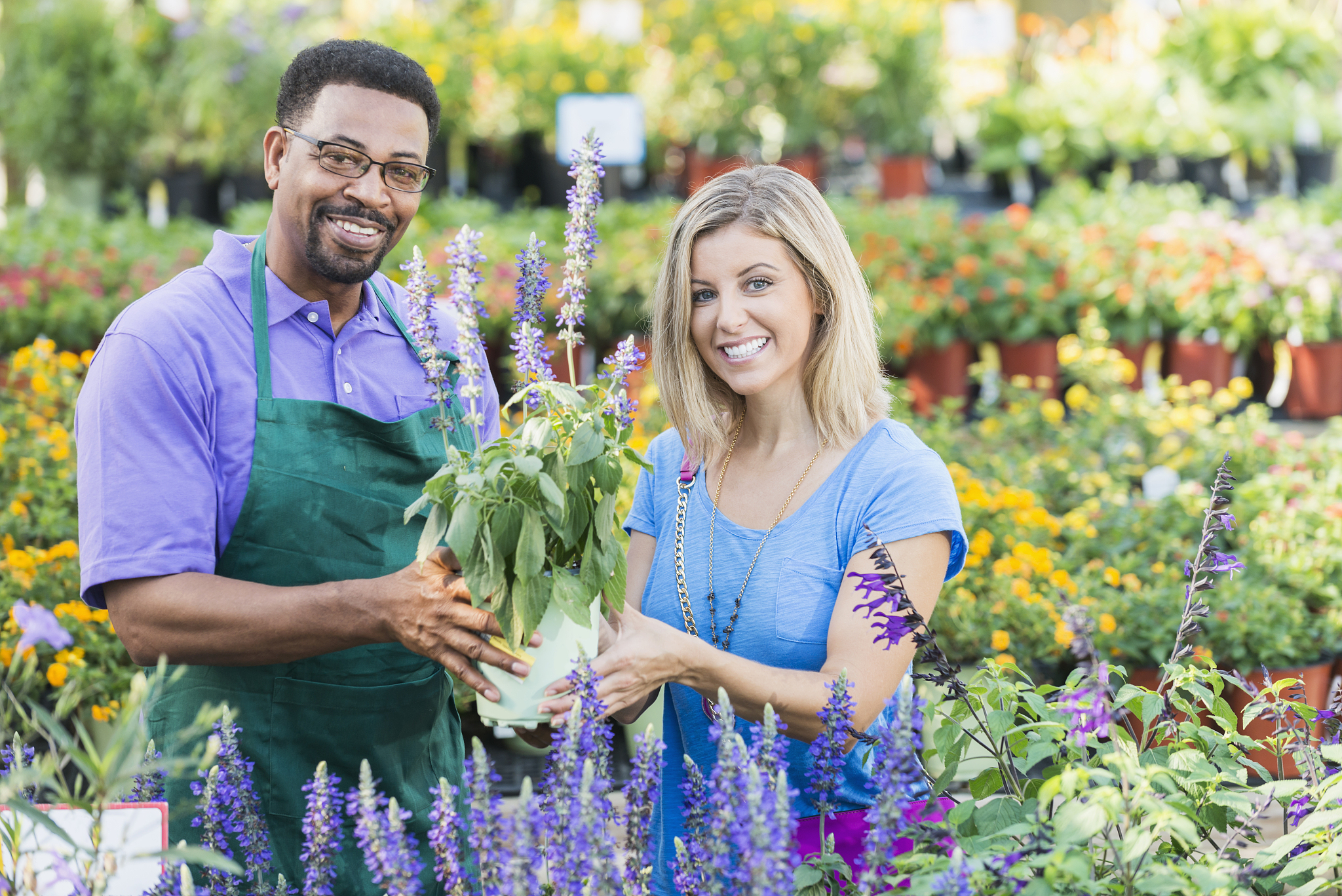 worker in plant nursery helping a customer