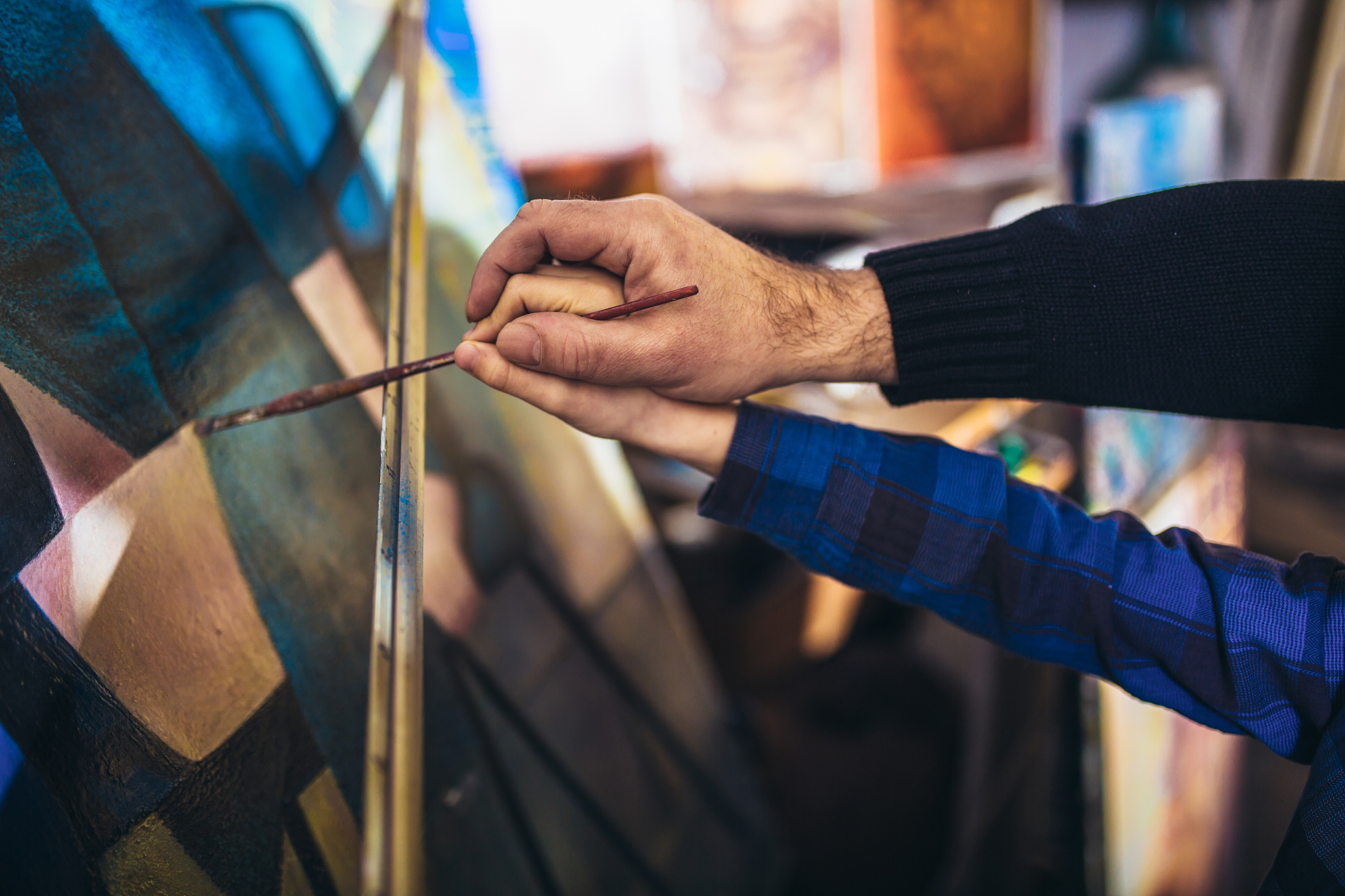 father and son working and painting together in art studio, clos