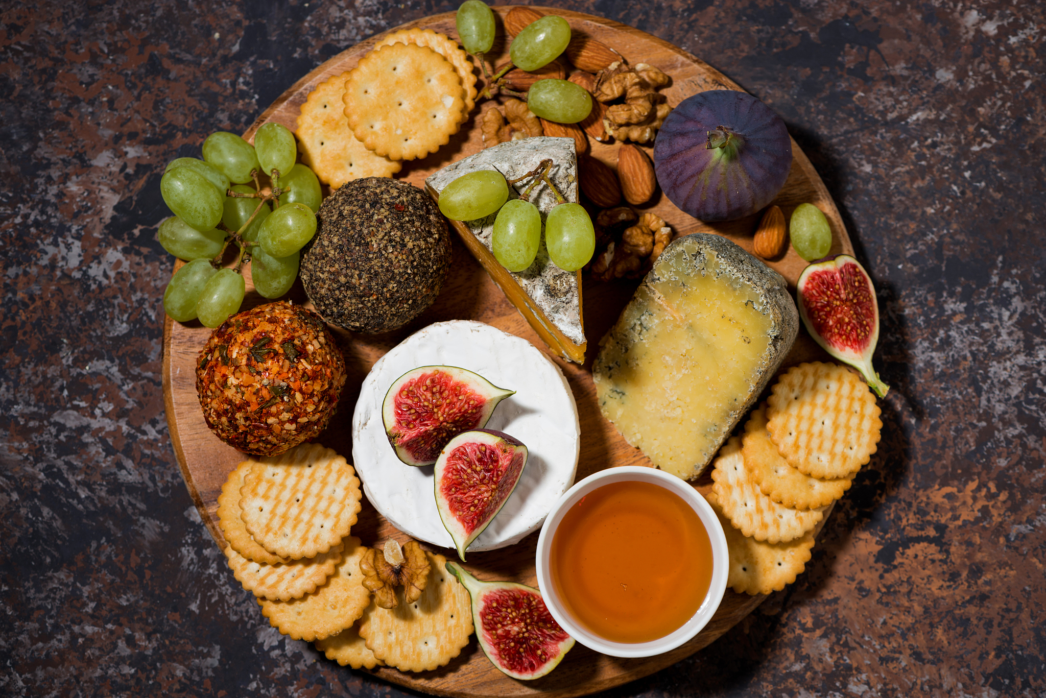 cheese, crackers and fresh fruits, delicious wine snacks on dark
