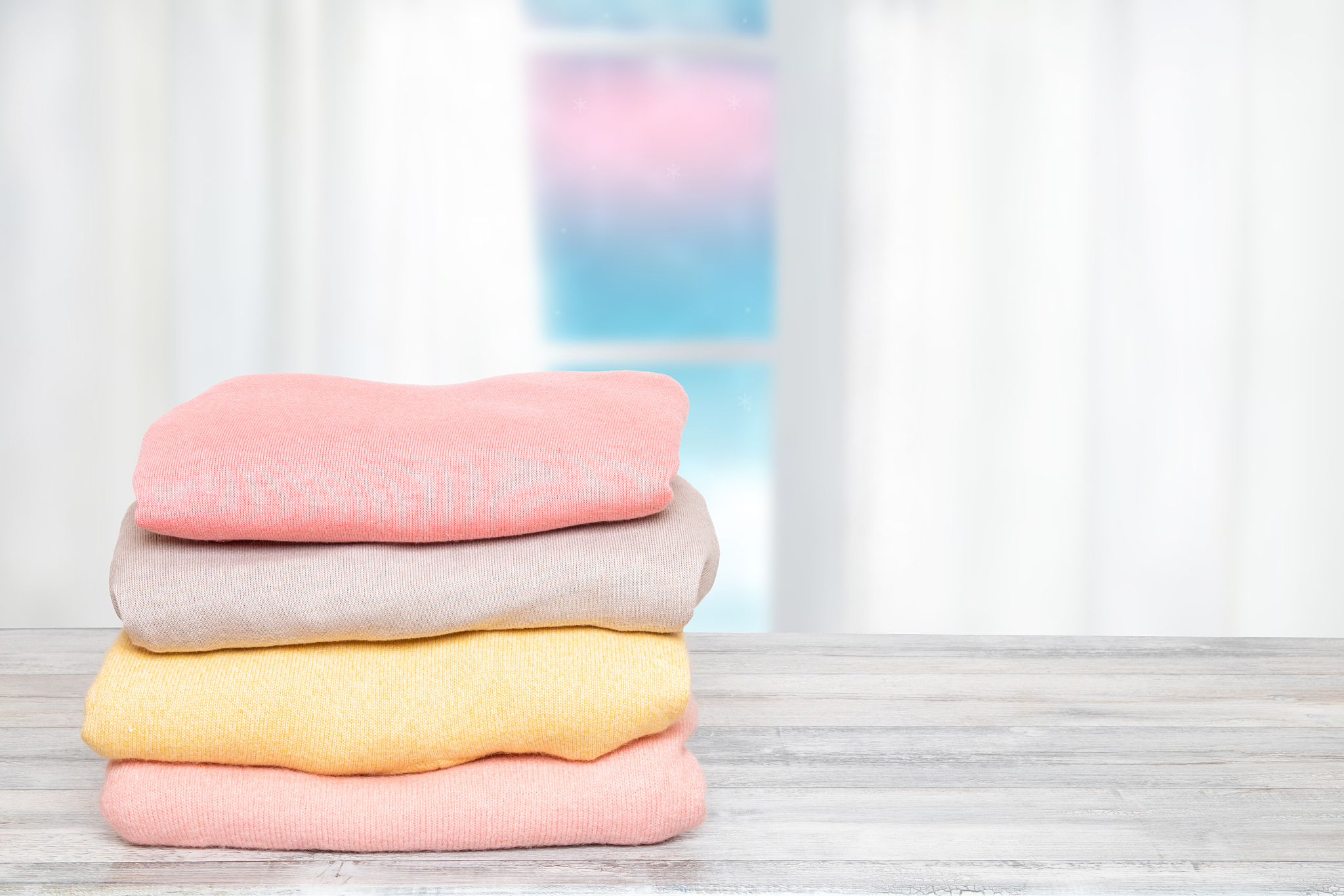 stack of winter clothes. pile of colorful knitted cozy warm cash