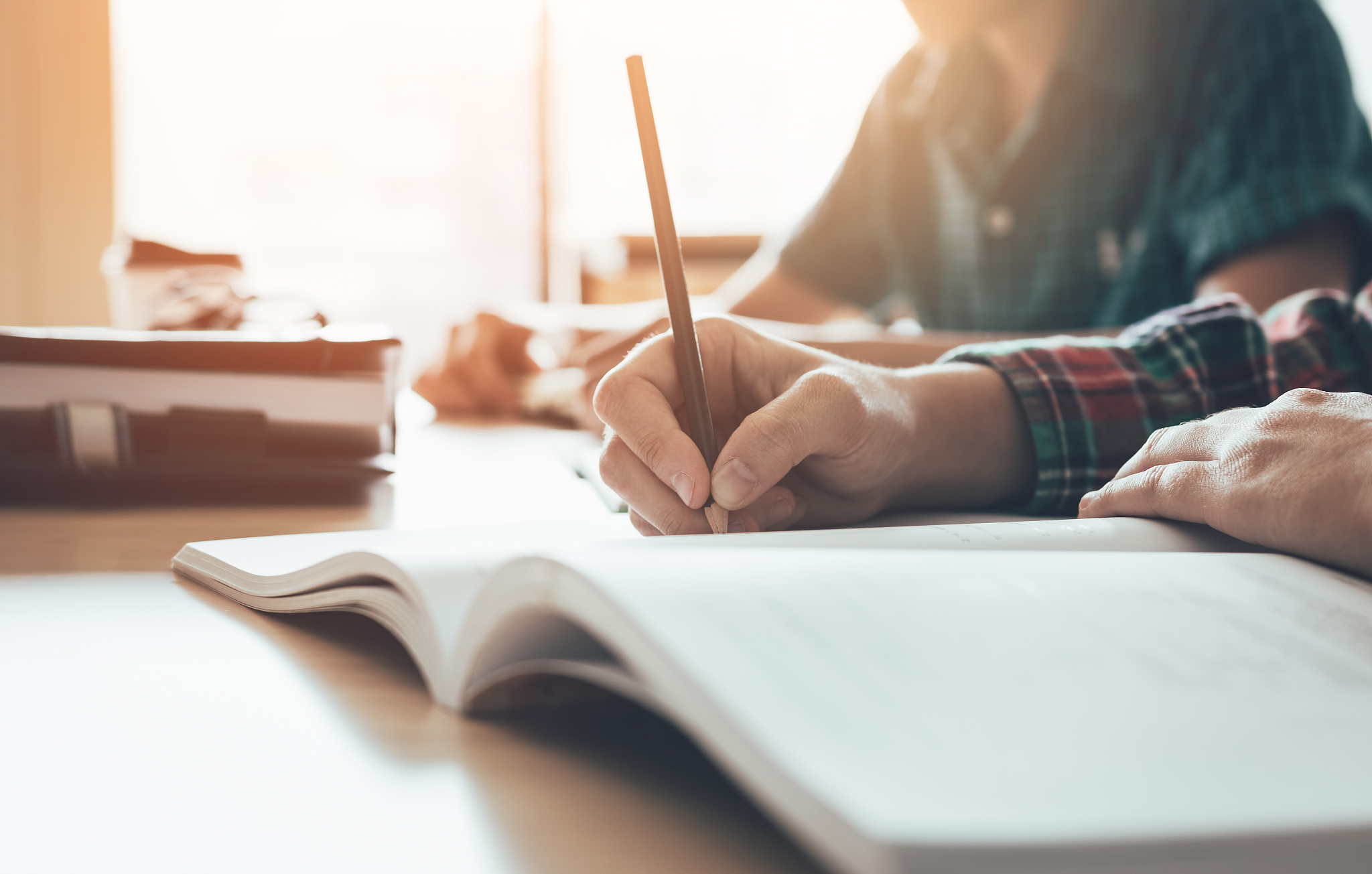 student is studying paper and writing test in modern classroom.