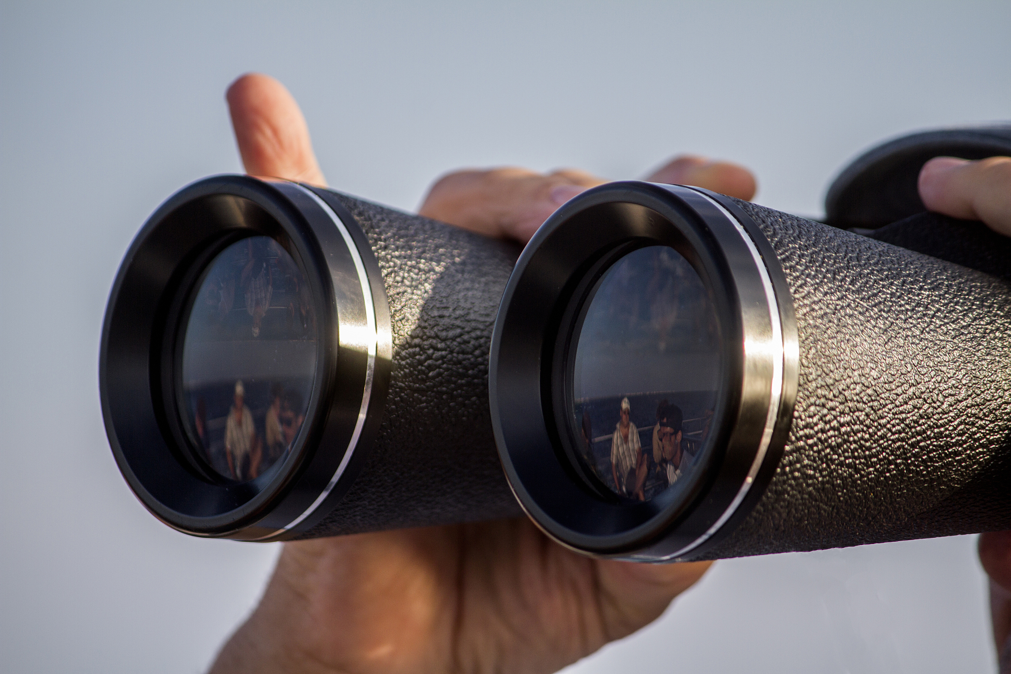man with binoculars watching the sea horizon