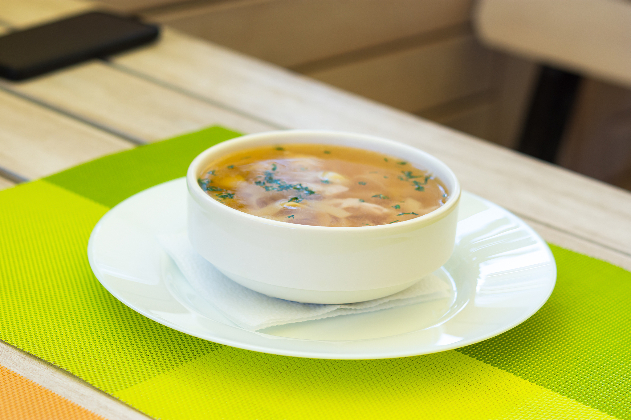 noodle soup in a summer cafe. soup with yellow broth in a white 
