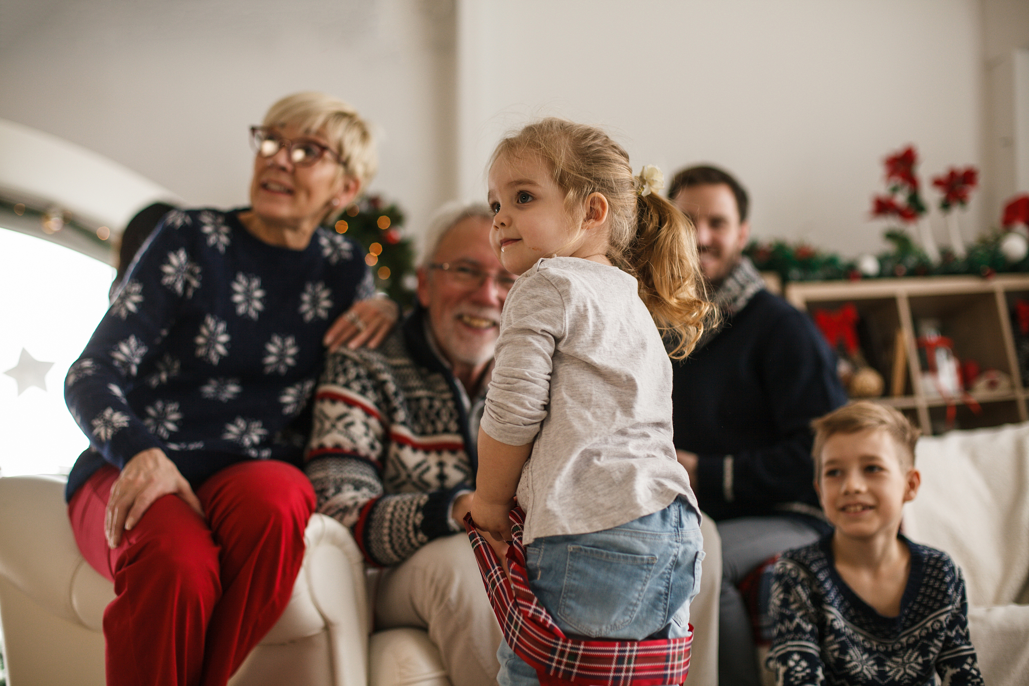 family having fun while children are opening their christmas pre
