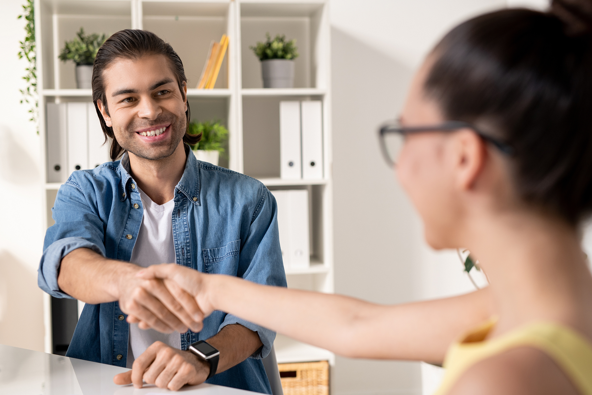 happy young successful businessman shaking hand of new business 