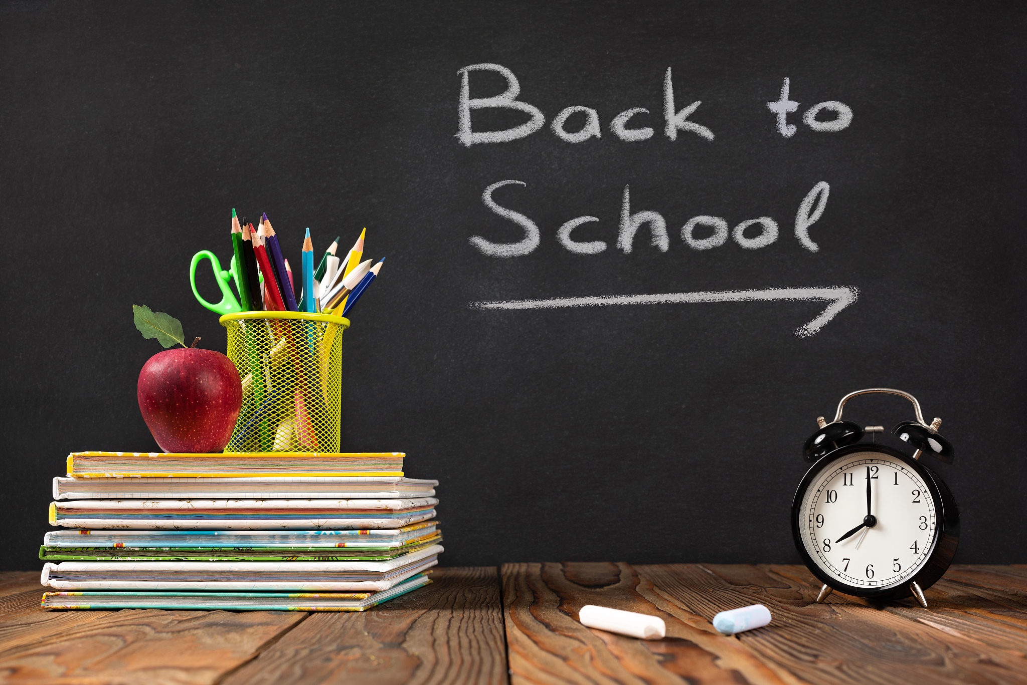 back to school concept with stationery supplies and blackboard