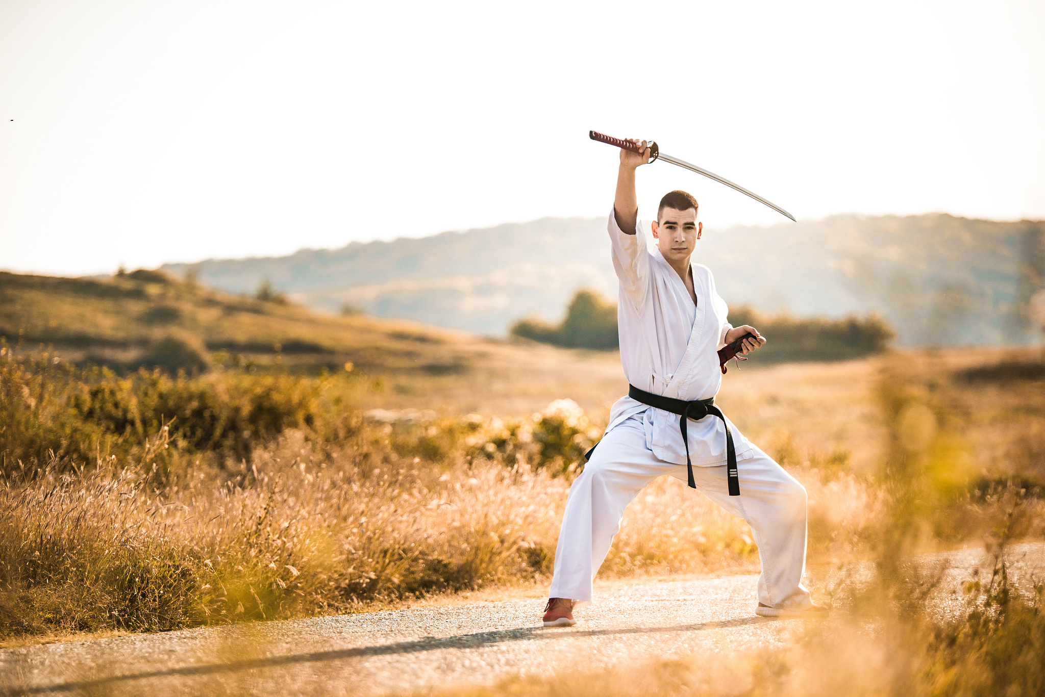 young martial artist practicing his skills with a katana sword.