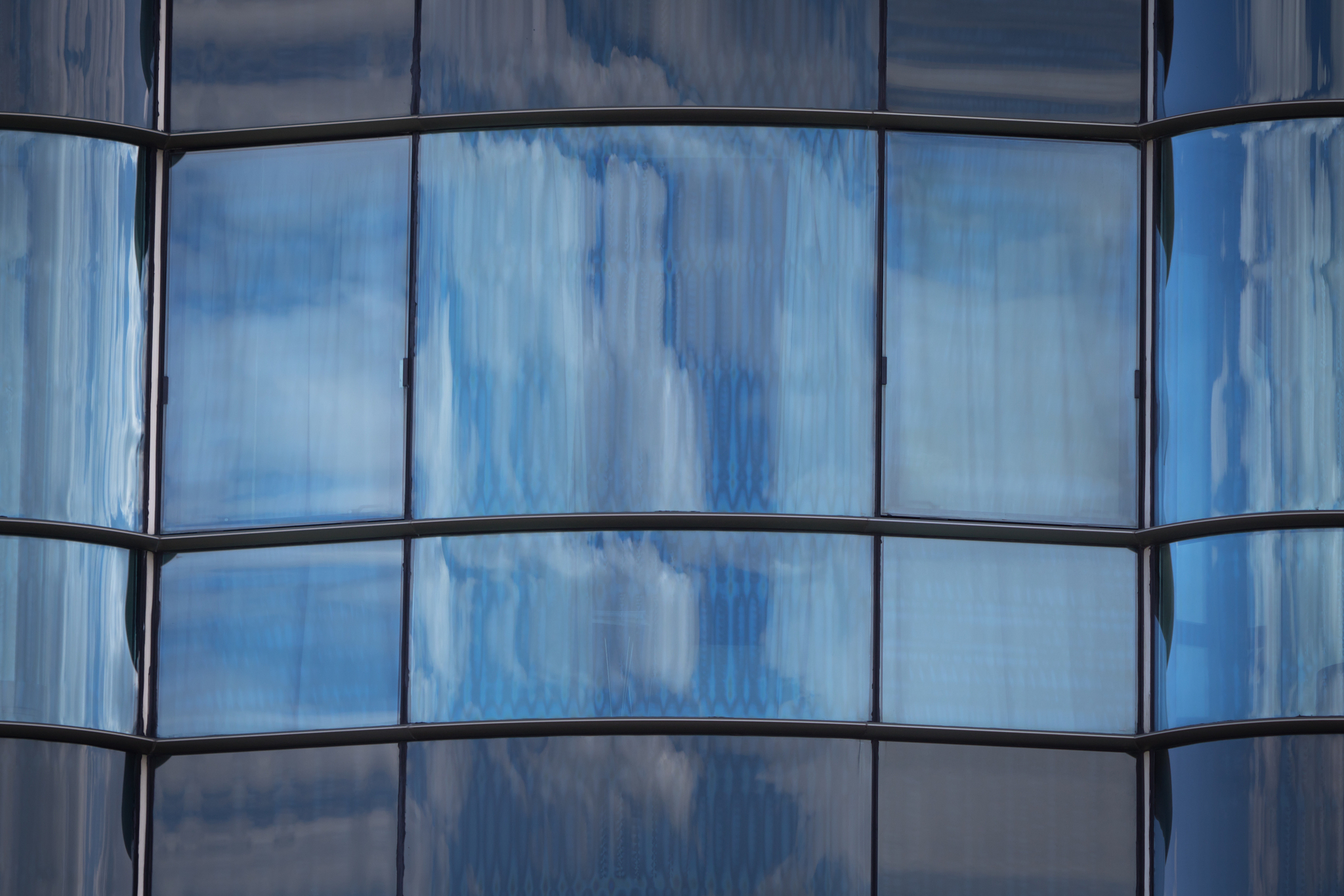 close up of blue modern architecture glass wall facade with refl