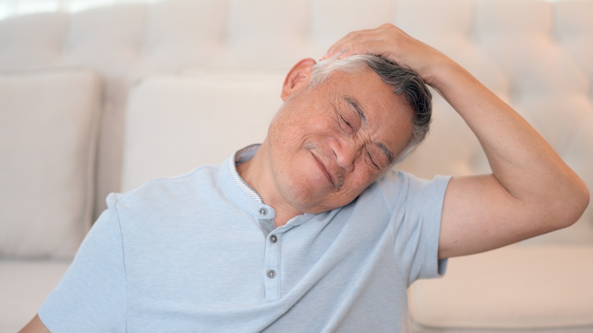 一位年长的亚裔商务人士在家中办公室使用笔记本电脑,