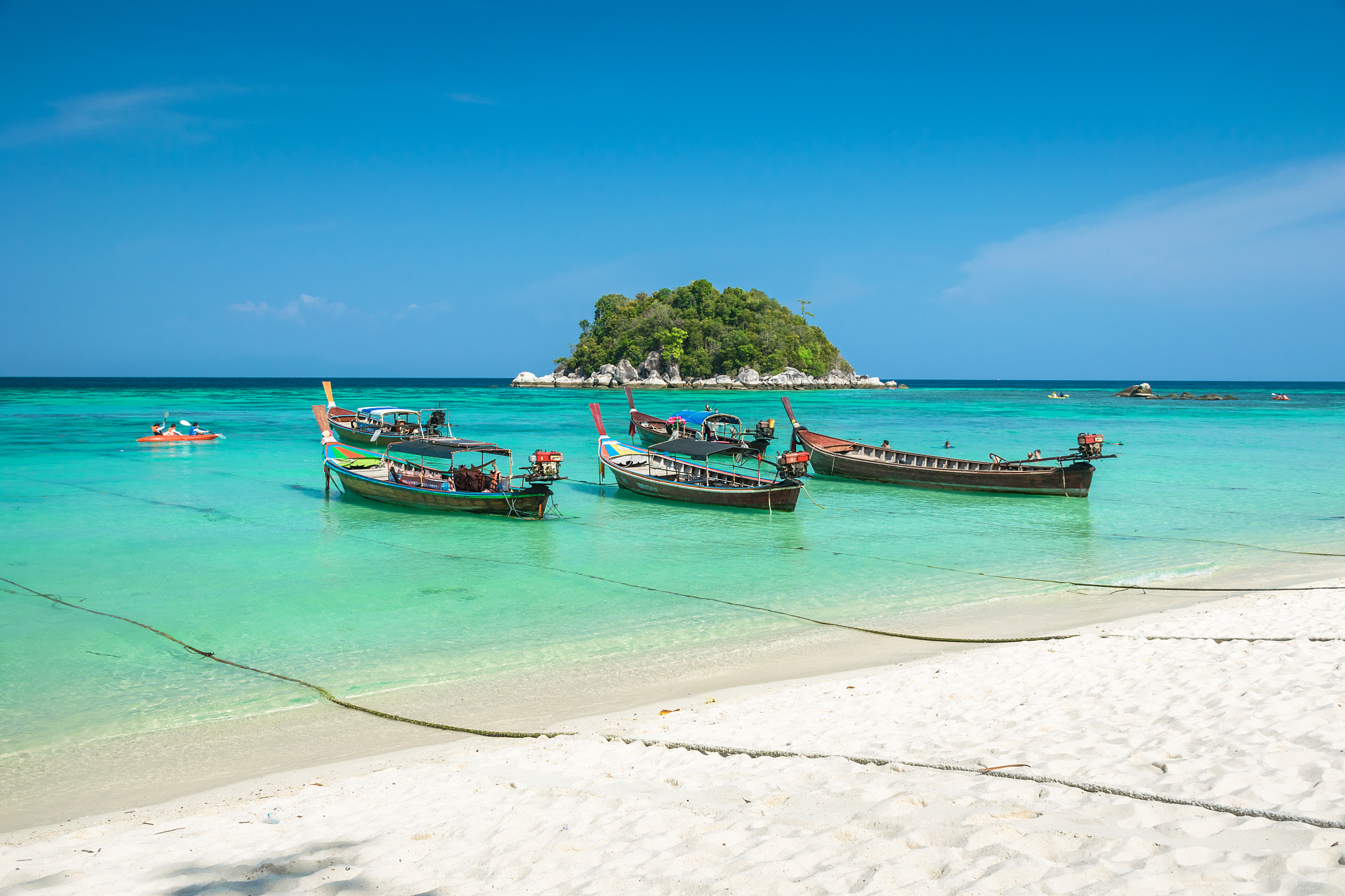 scenic view of longtail boats on the beach against sky at koh li