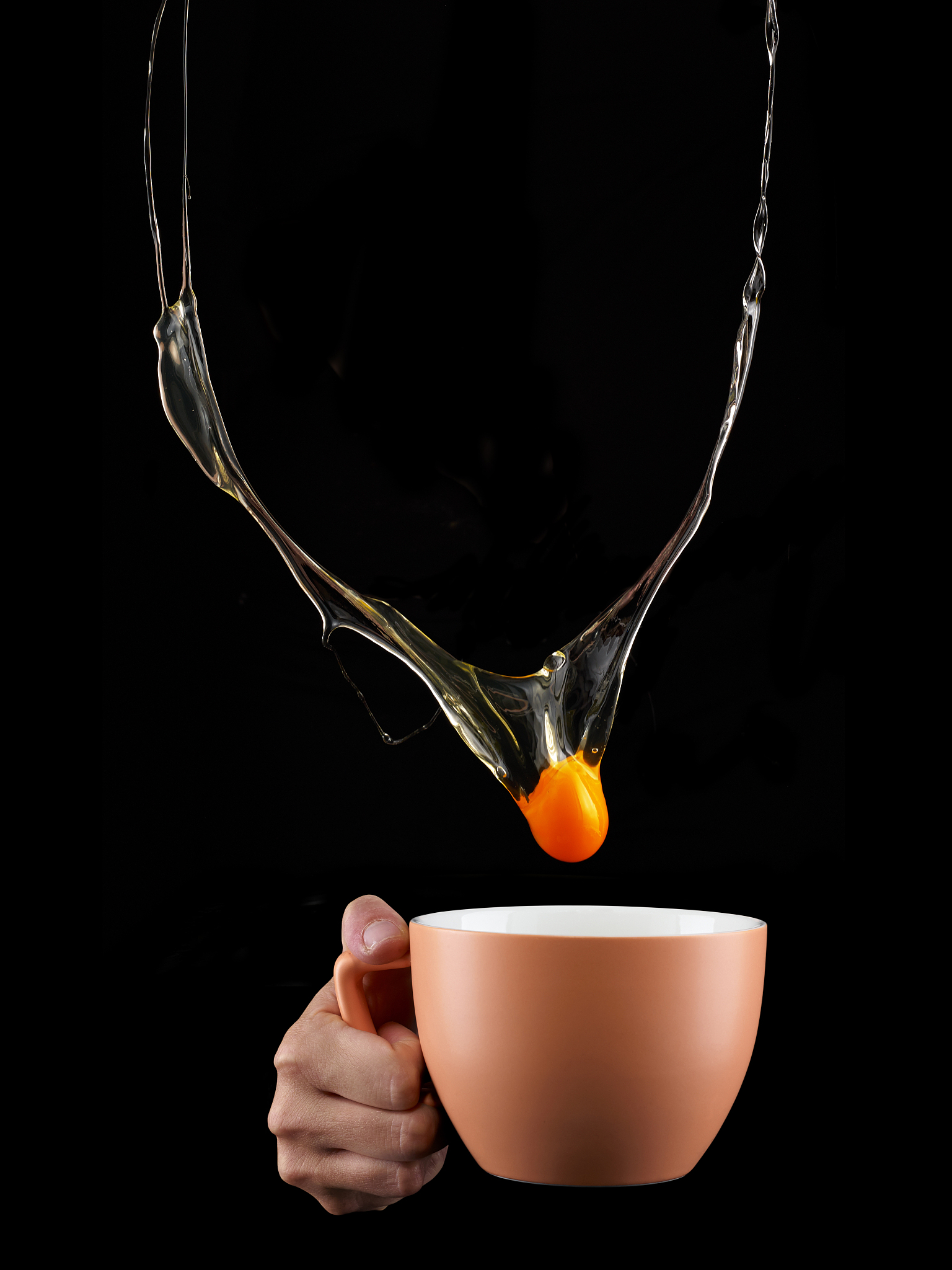 egg yolk dripping in to cup.