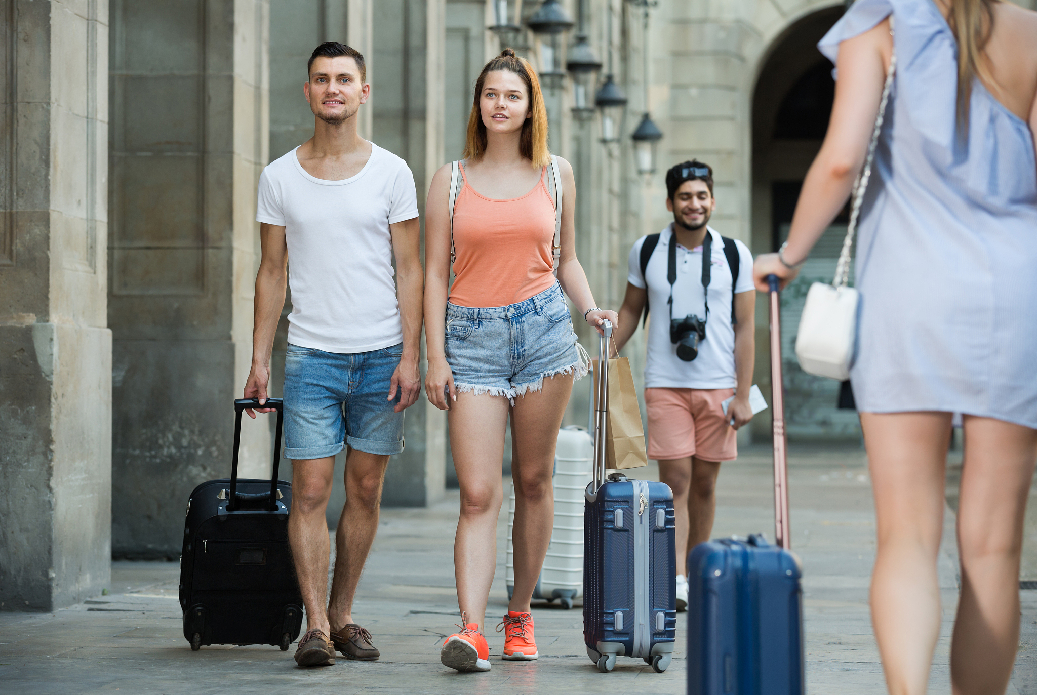 happy man and woman in shorts with luggage