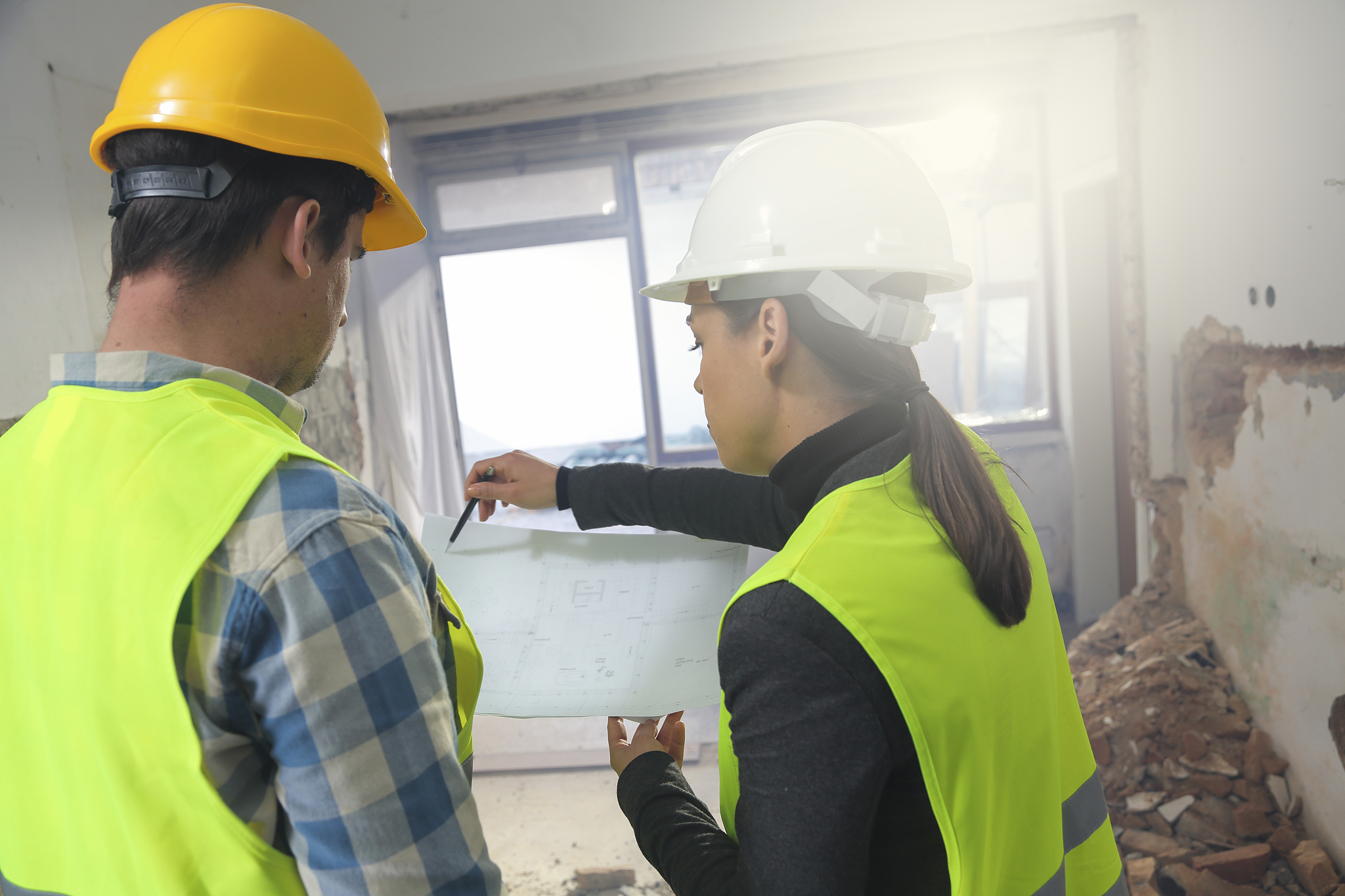 examining blueprints at construction site