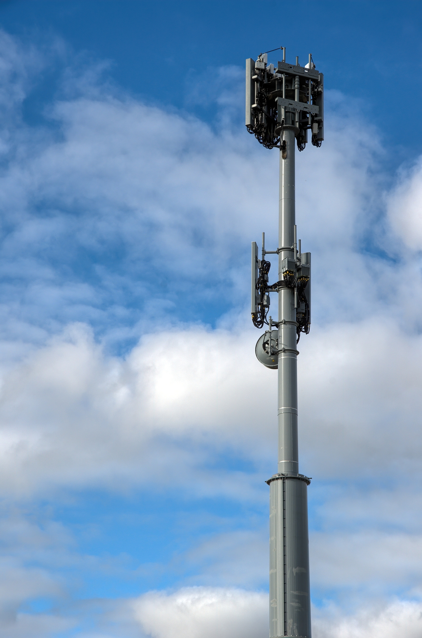 mobile phone repeater tower against a cloudy blue sky