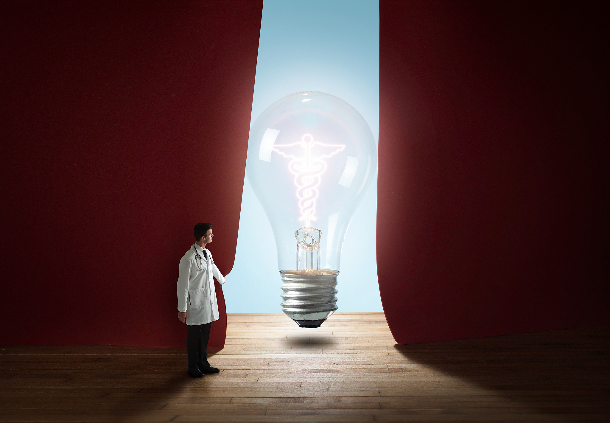scientist presenting lightbulb on stage