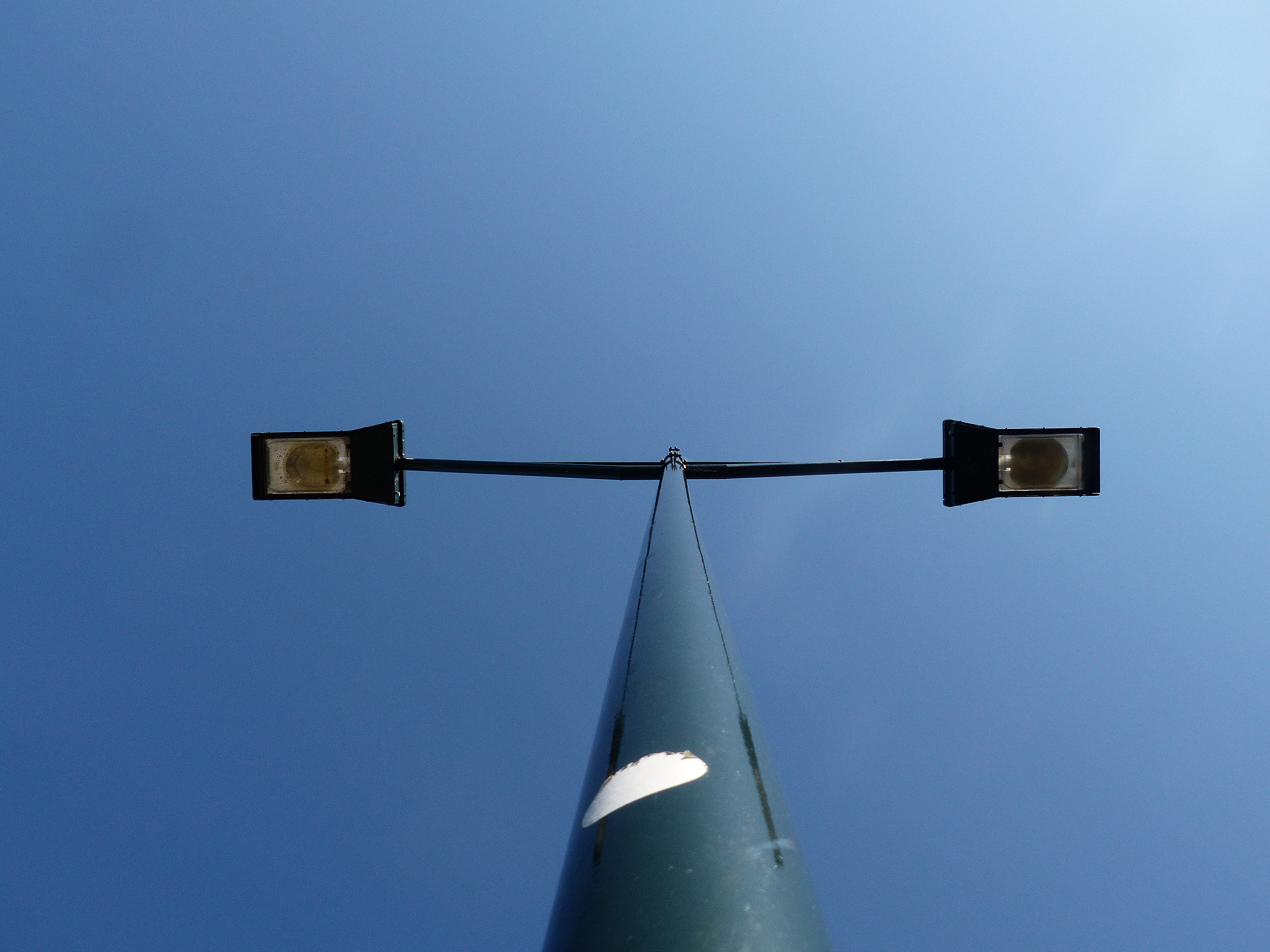 low angle view of street lights against clear blue sky during su