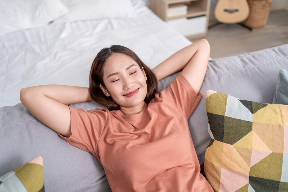 亚洲美女在家舒适的沙发上休息.年轻迷人的女子在假期