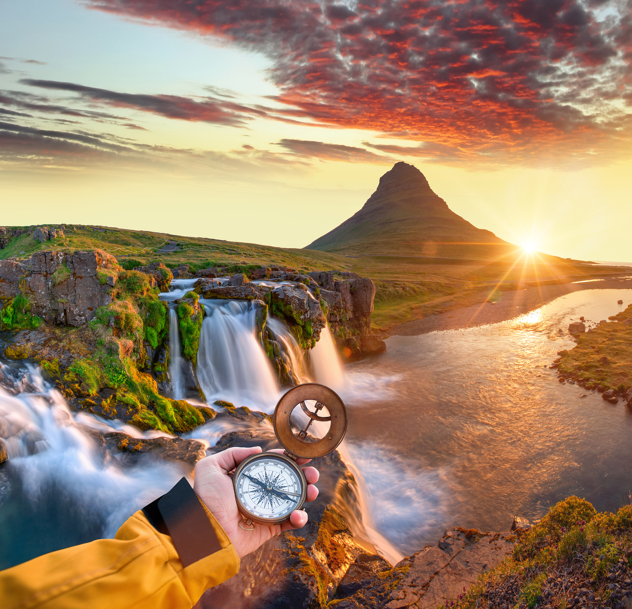 beautiful landscape with old compass on traveler's hand.
