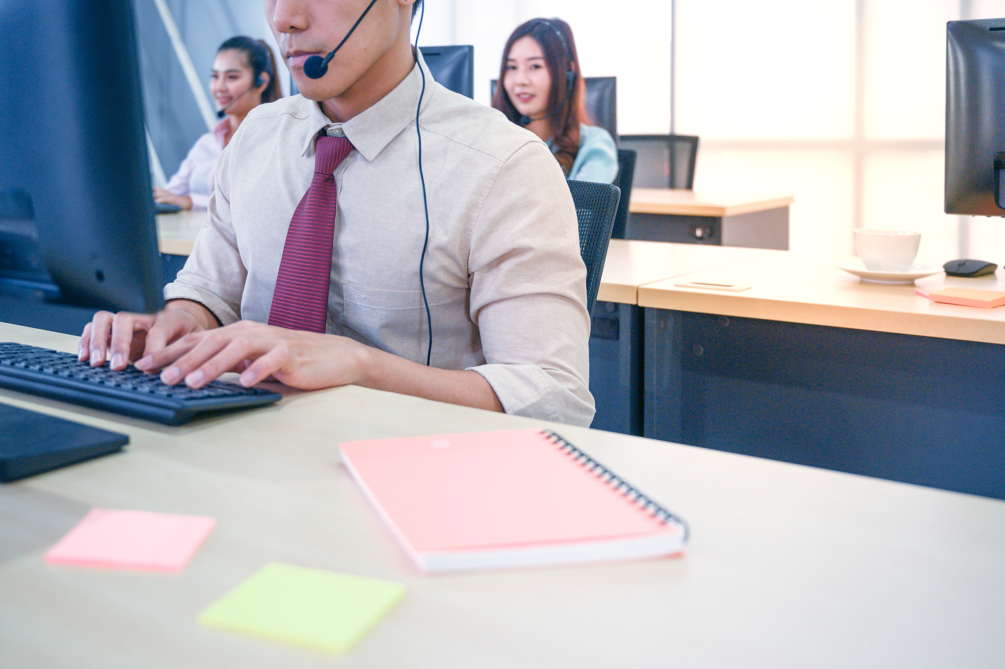 young customer service men agent with headsets and computer work