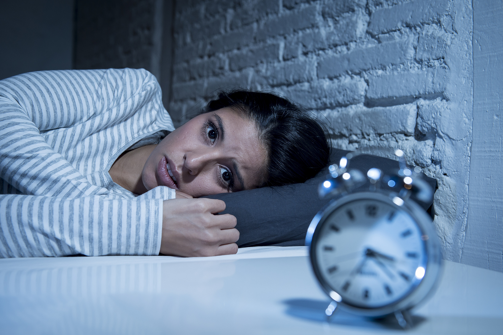 woman in bed late night trying to sleep suffering insomnia