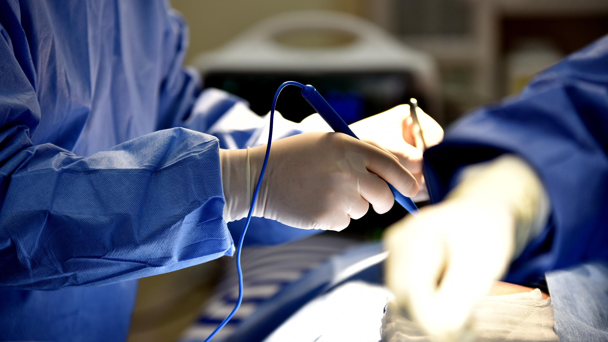 doctors holding equipment in operating room