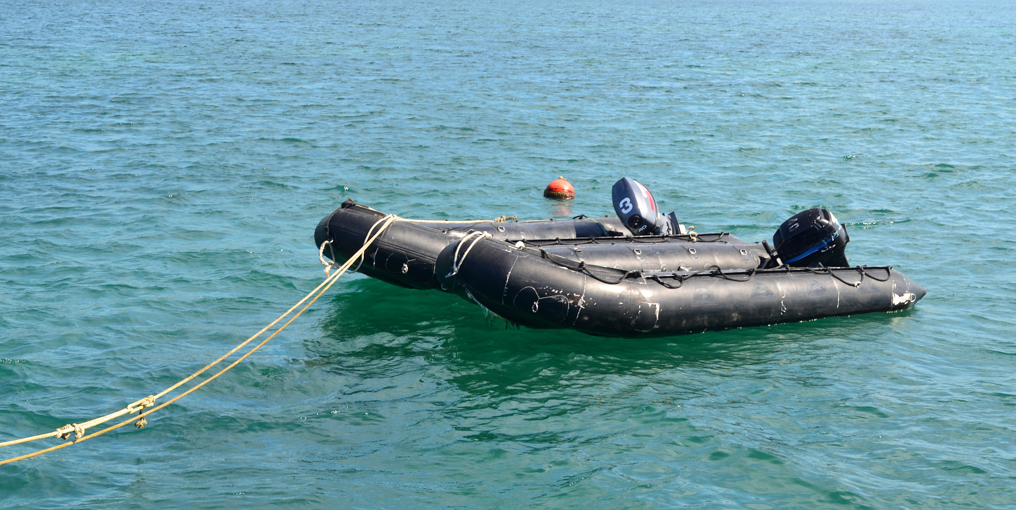 two black rescue boats on the sea