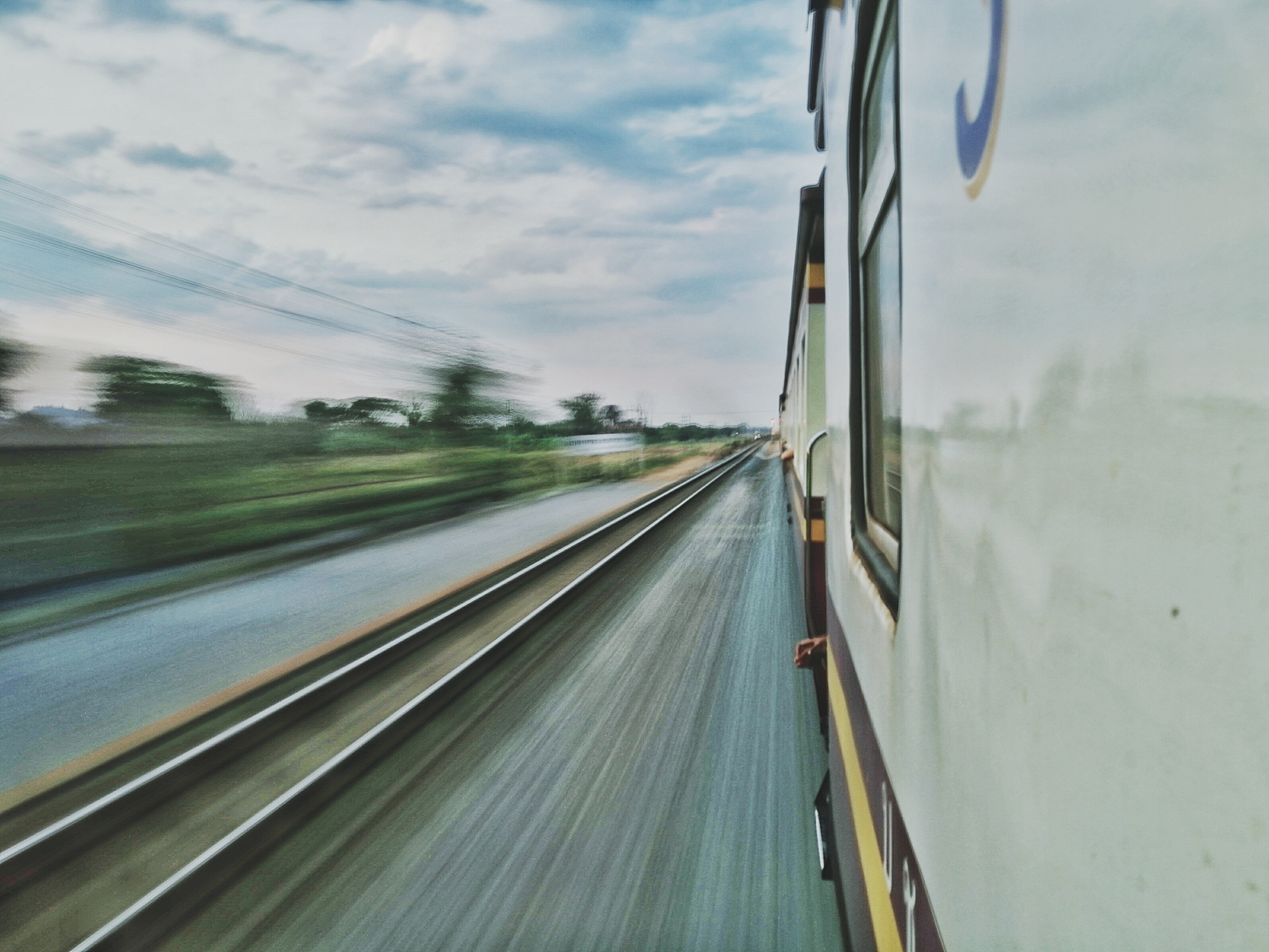 我想生成一个白天和谐号动车行驶在铁路上的图请你帮我描述一下这个画面然后请帮我简化一下变成英文词让我可以在Midjourney上使用