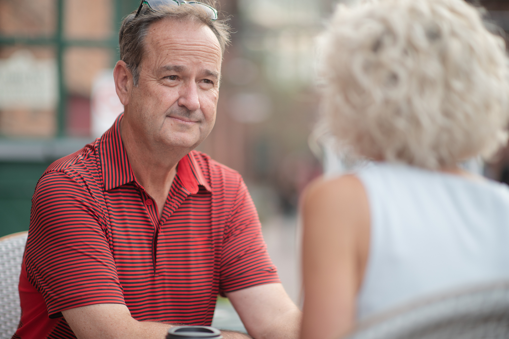 senior man sits outside with his wife stock photo