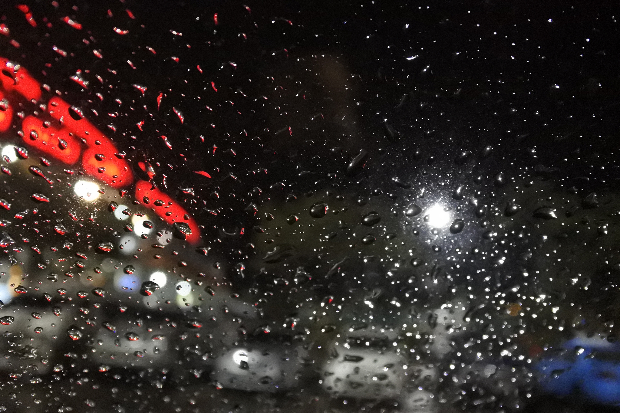 rain drops on window with street bokeh lights