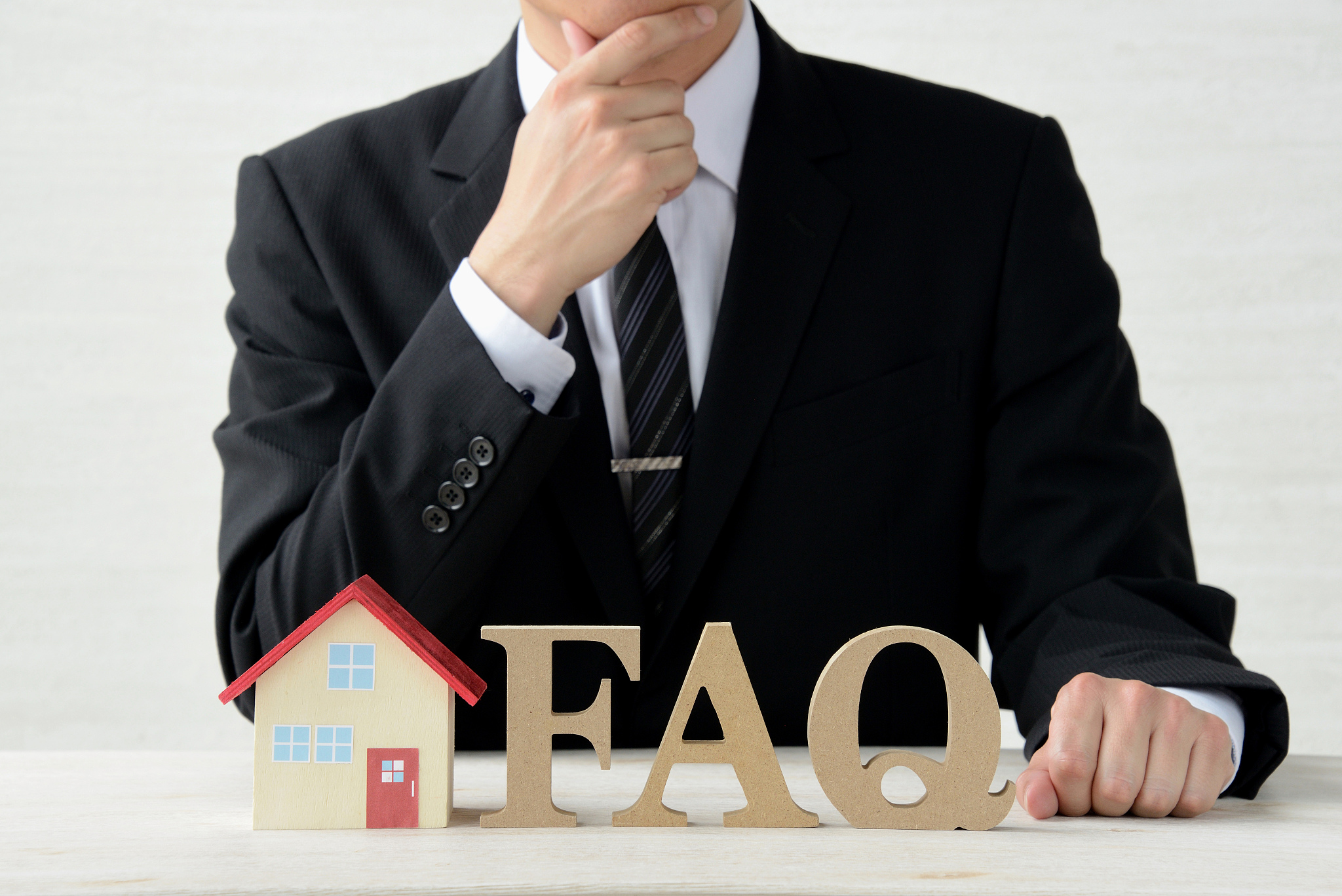 business man with house and faq objects