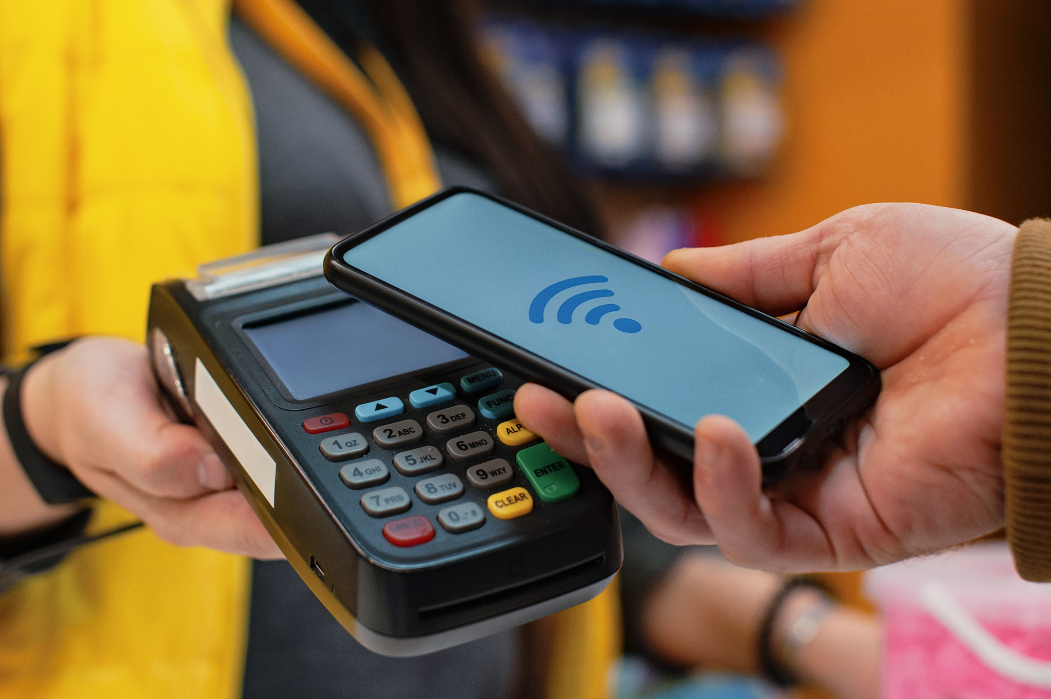customer is paying with smartphone in shop using nfc technology.