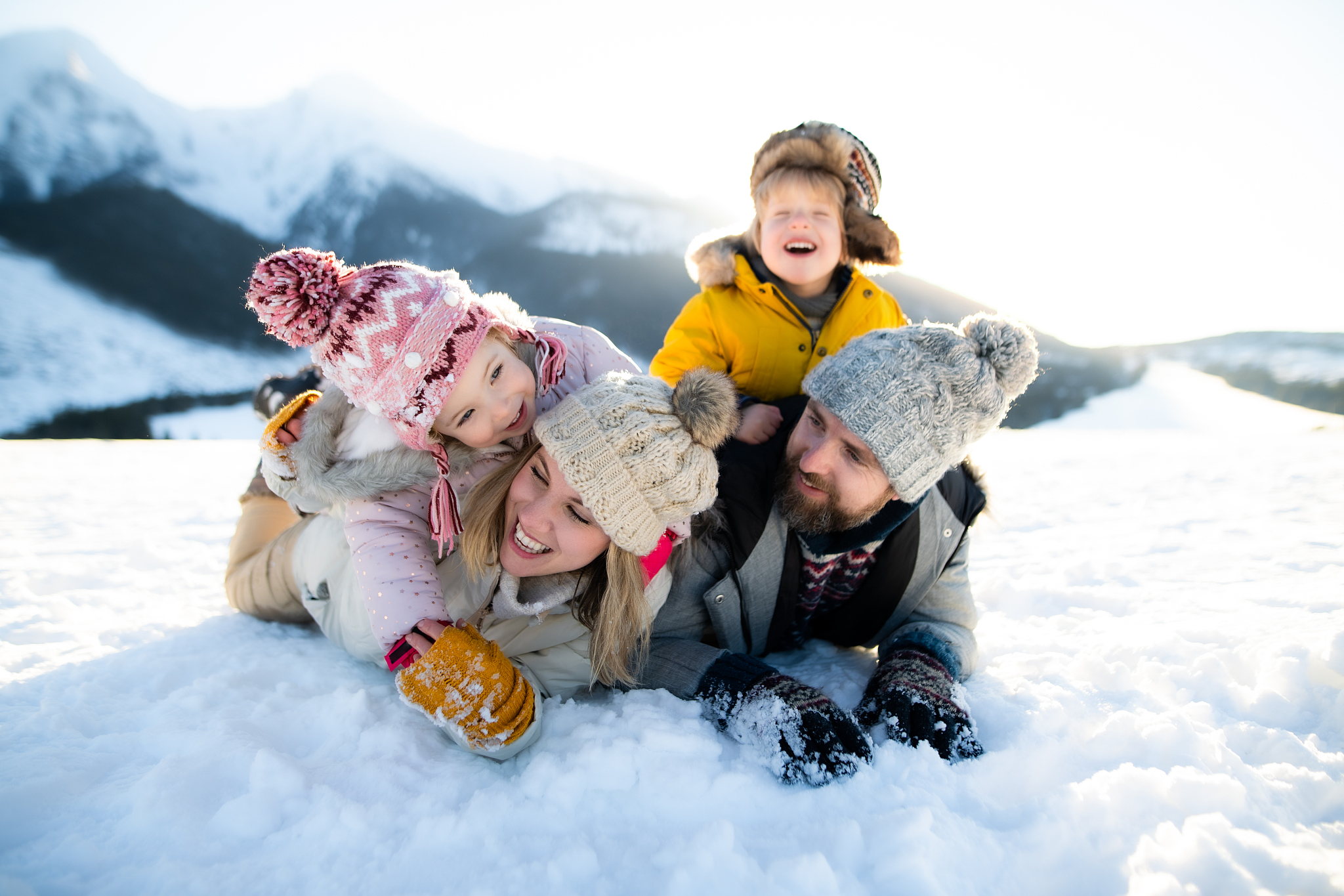 portrait of family with two small children enjoying snow in wint