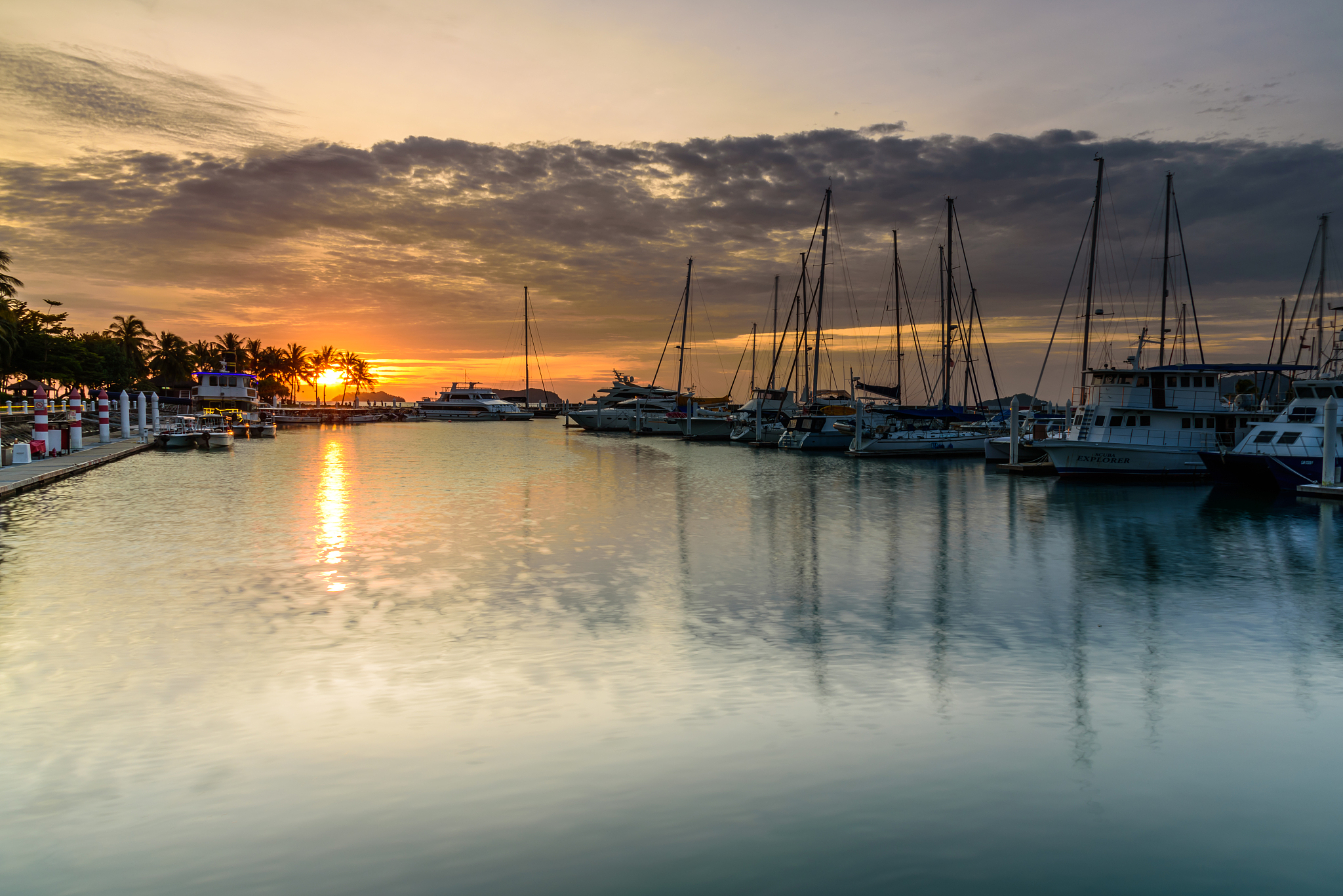 boats moored at harbor against sky during sunset