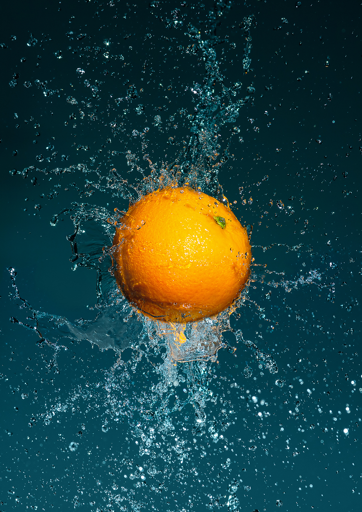 flying ripe orange in water splashes