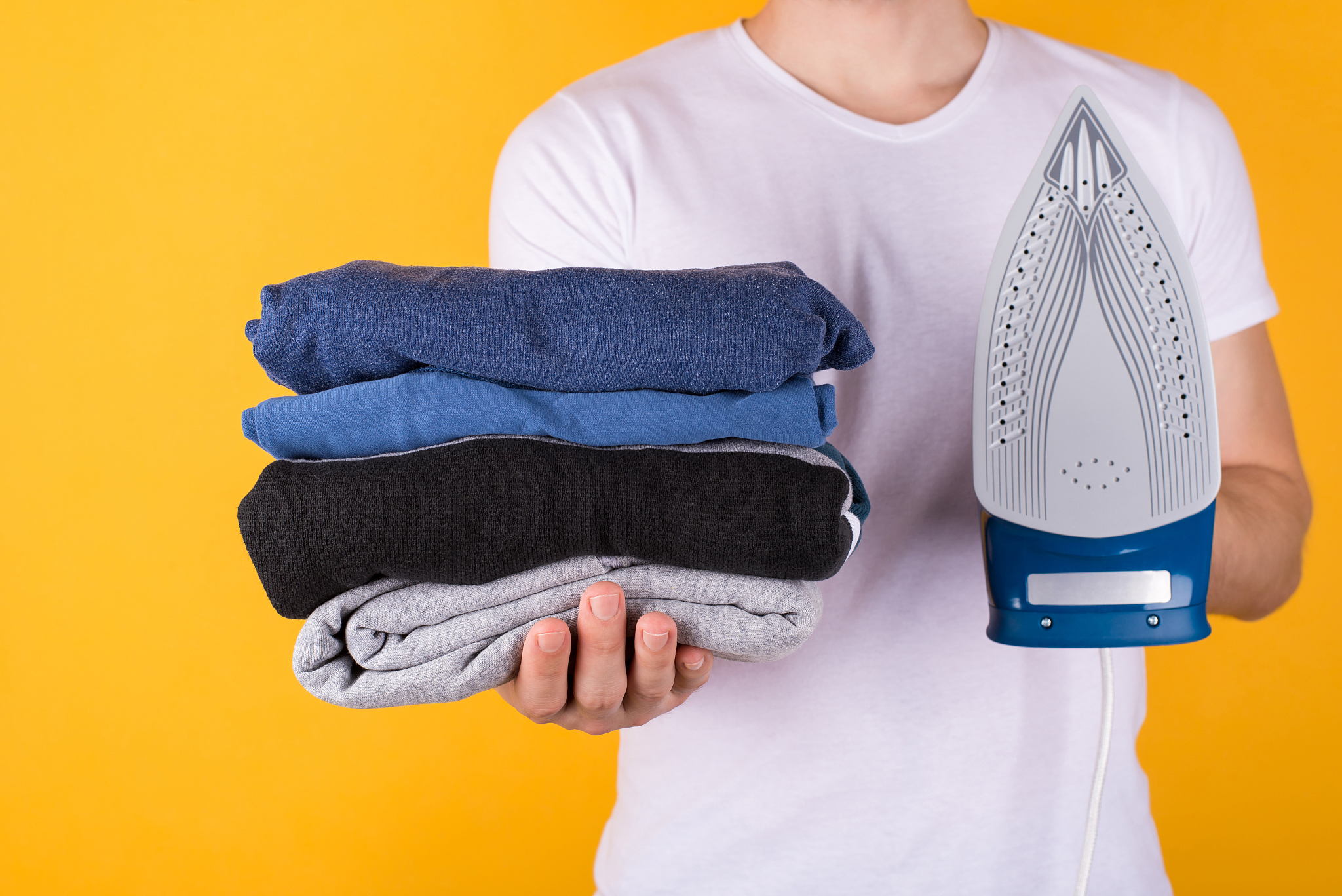 ironing clothes concept. cropped photo of a man holding stack of
