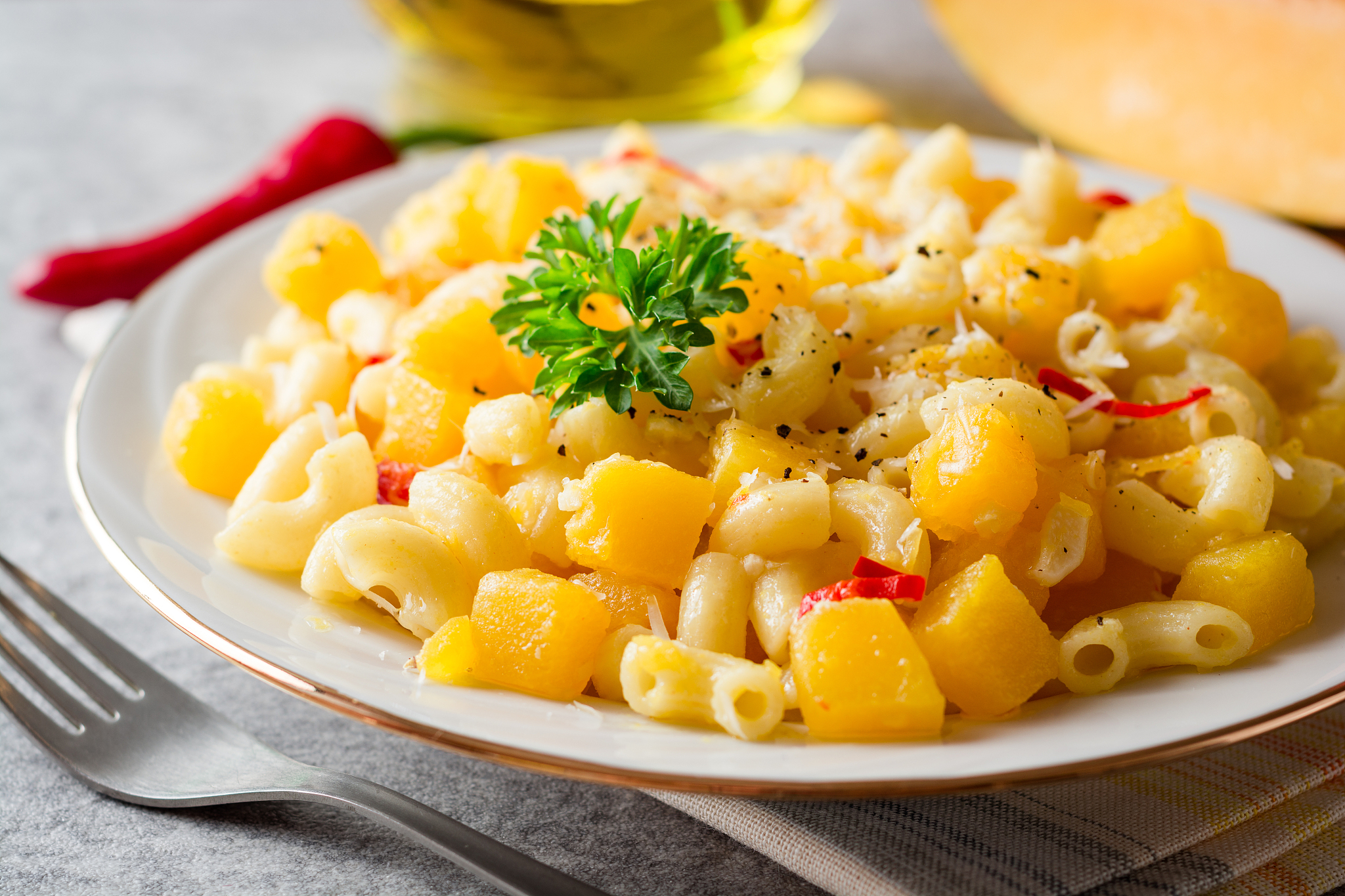 pasta with pumpkin, chili and cheese in plate on stone backgroun