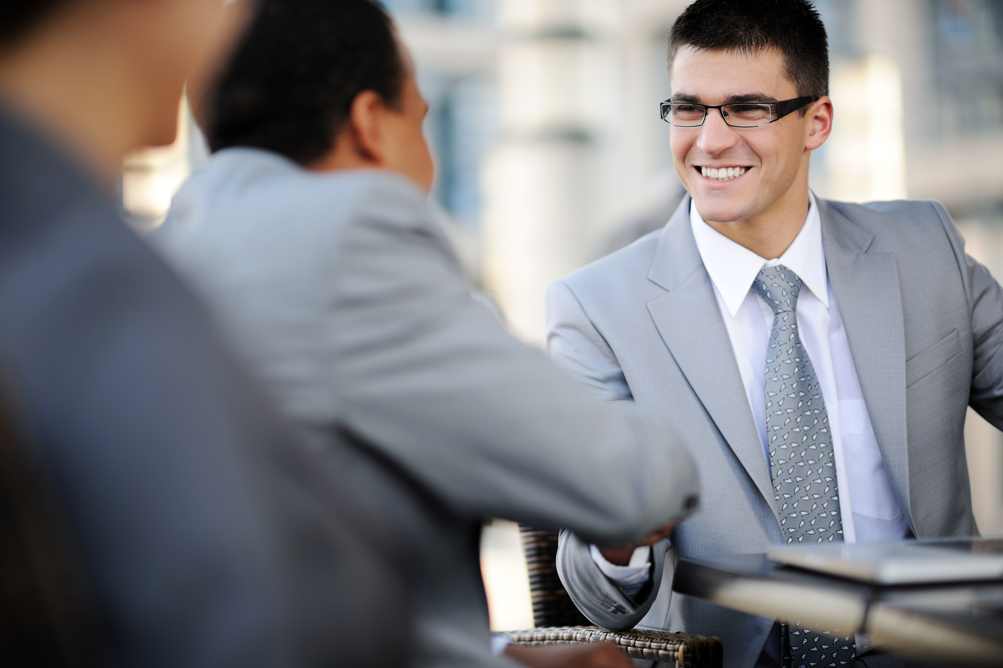 businessman with glasses shakes colleague's hand