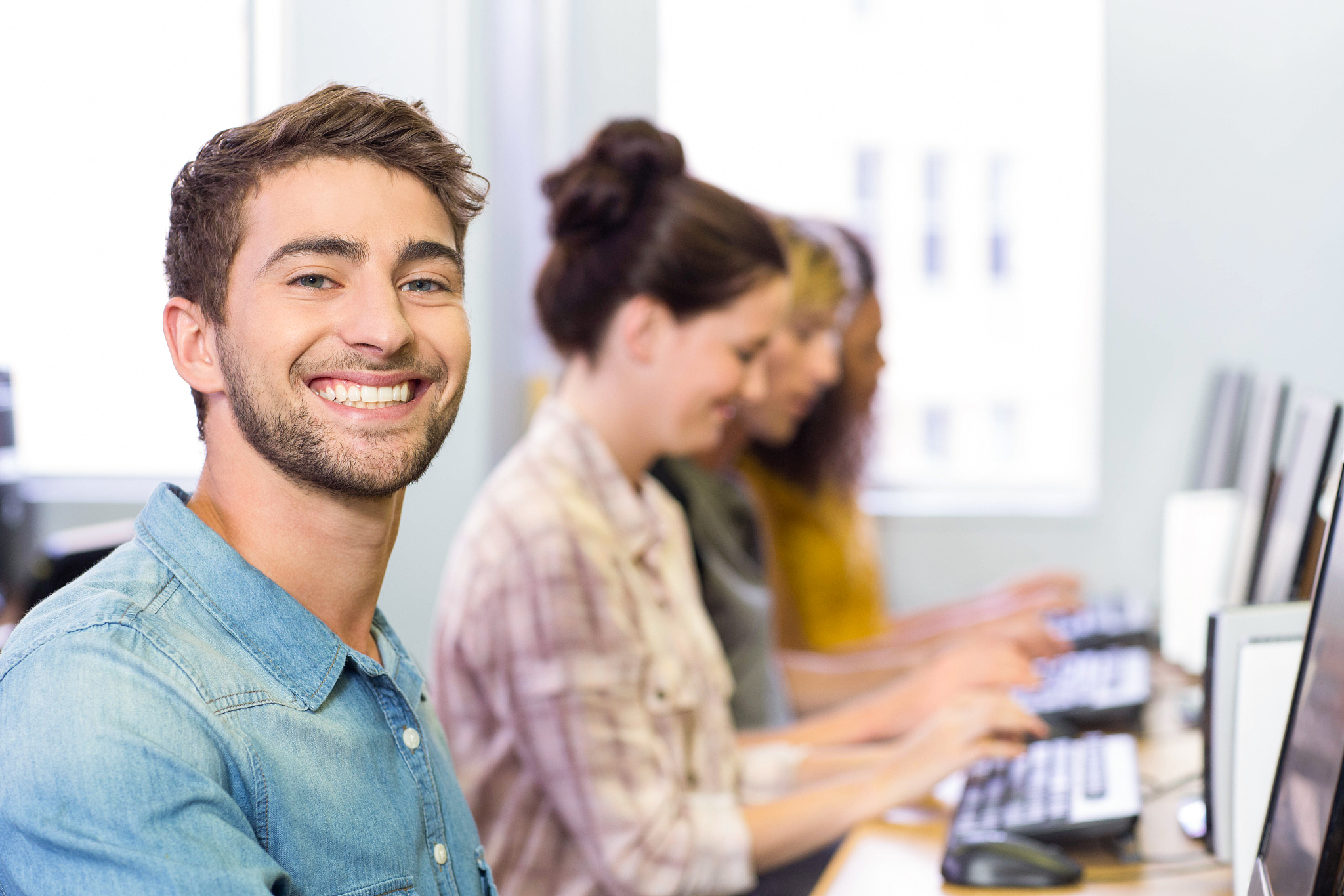 student smiling at camera in computer class
