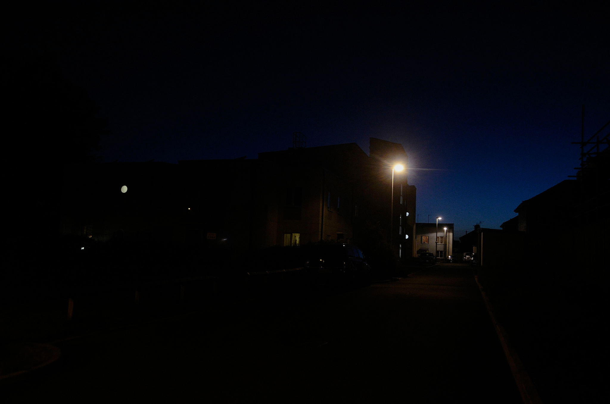 street by buildings in city against sky at night