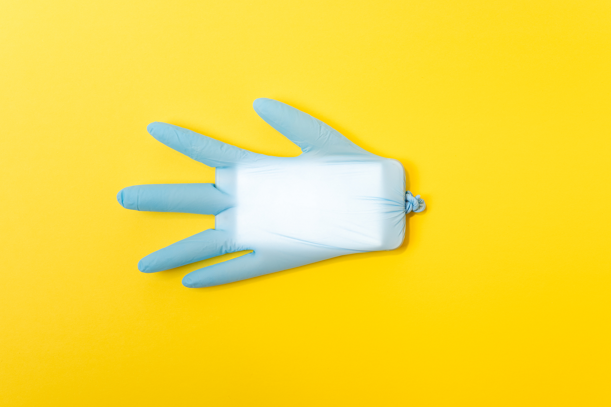 blue latex medical glove with mobile phone inside. minimal coron