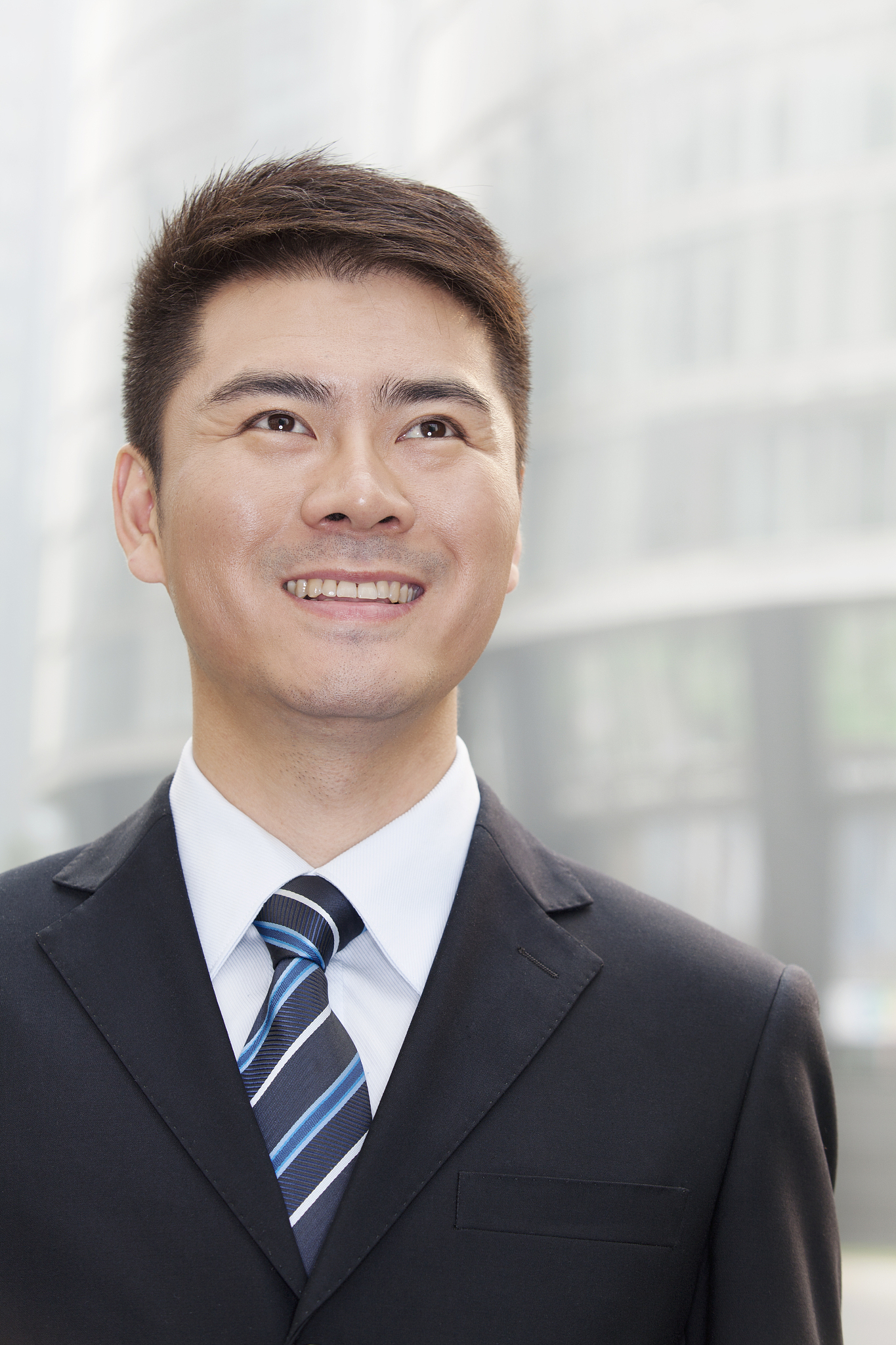 young businessman smiling and looking up, portrait