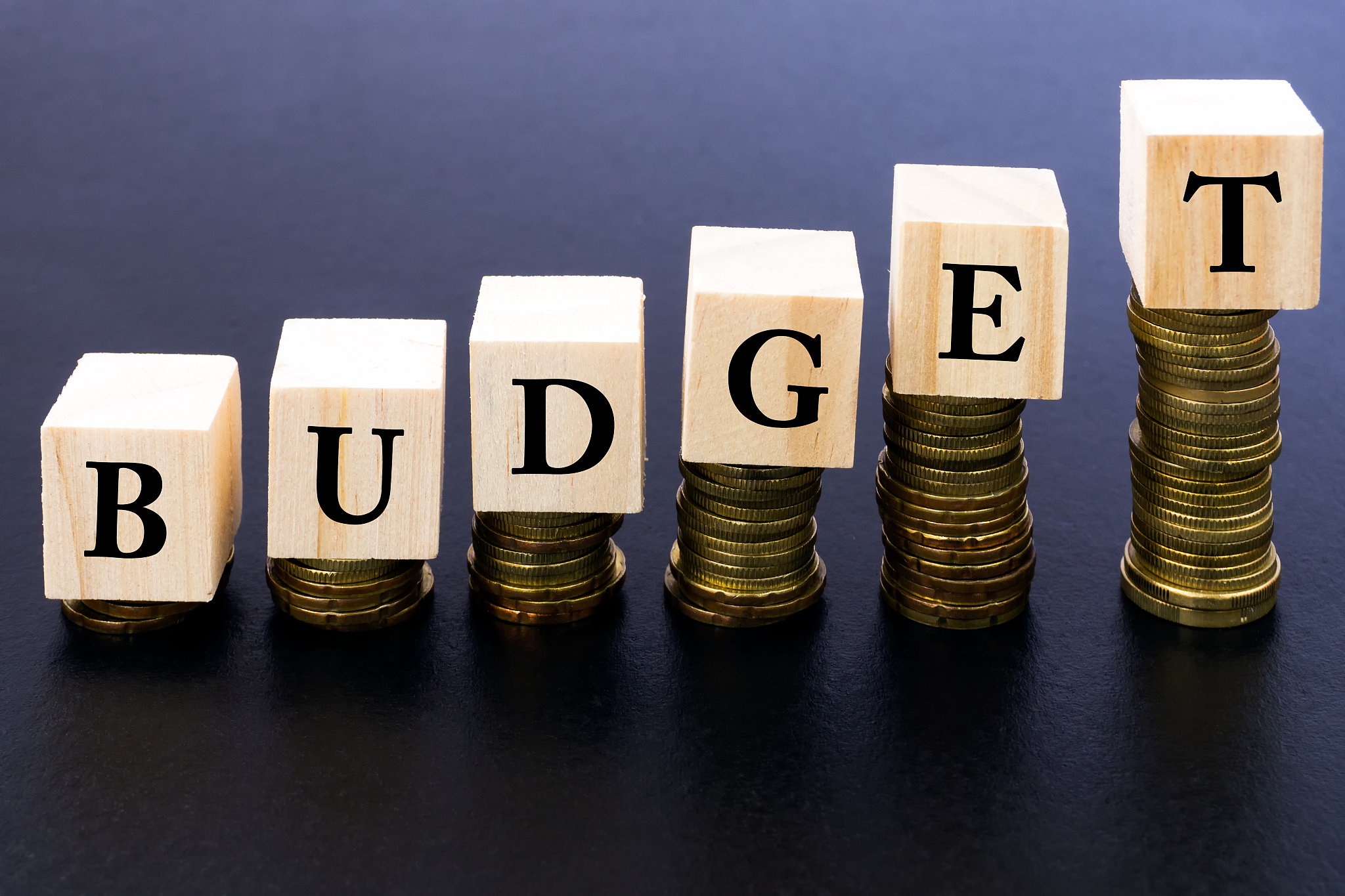 budget word on wood block on top of coins stack.