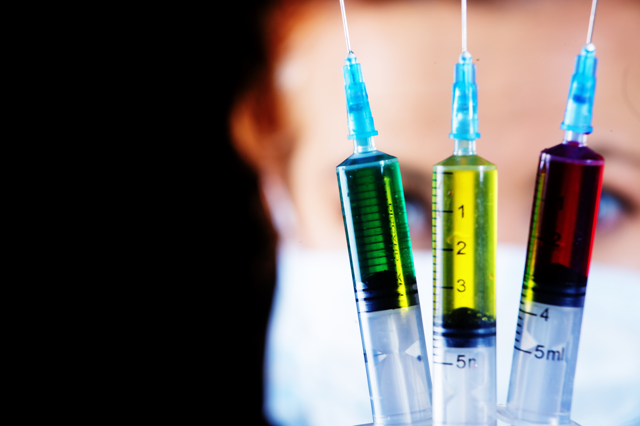 doctor holds three syringes