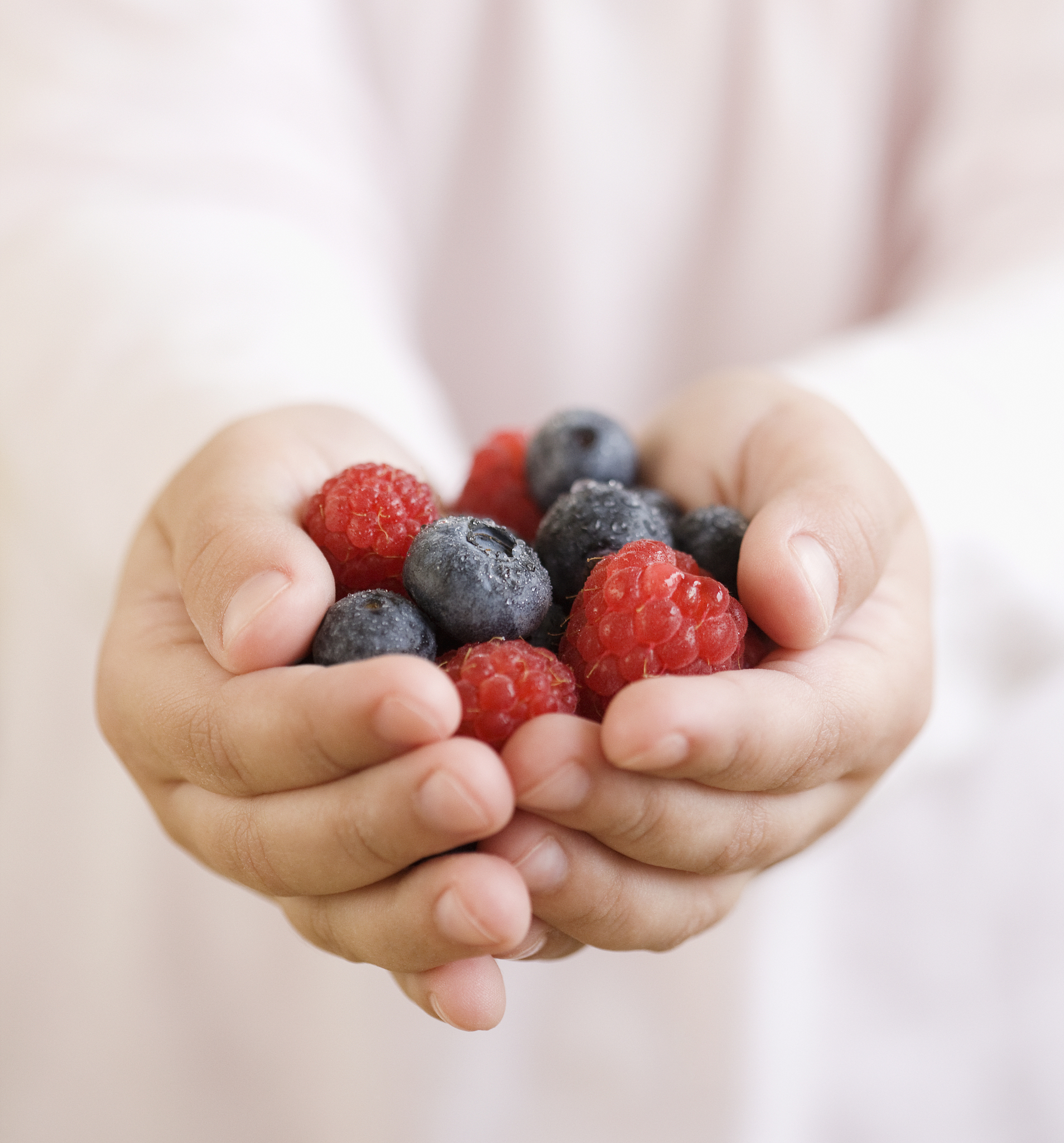 child holding handful of berries