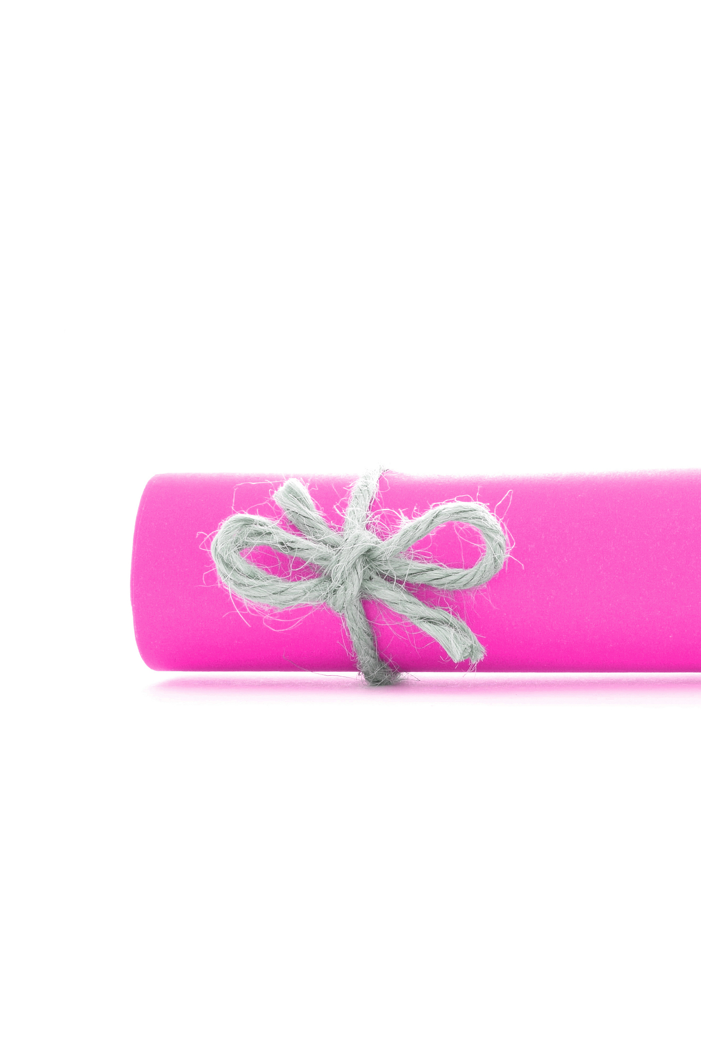 handmade natural cord bow tied on pink paper scroll isolated