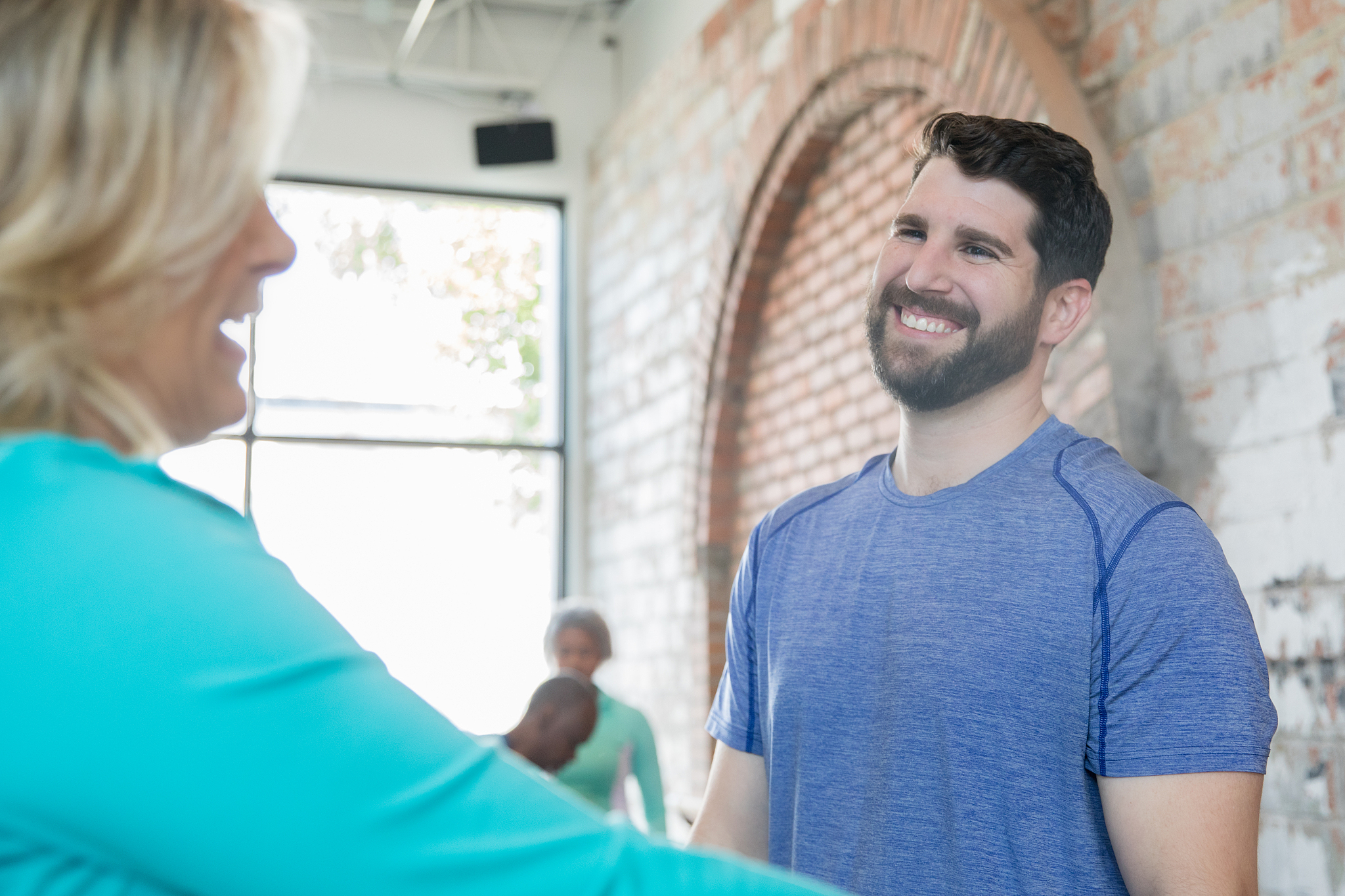 mid adult man working as physical therapist or personal trainer 
