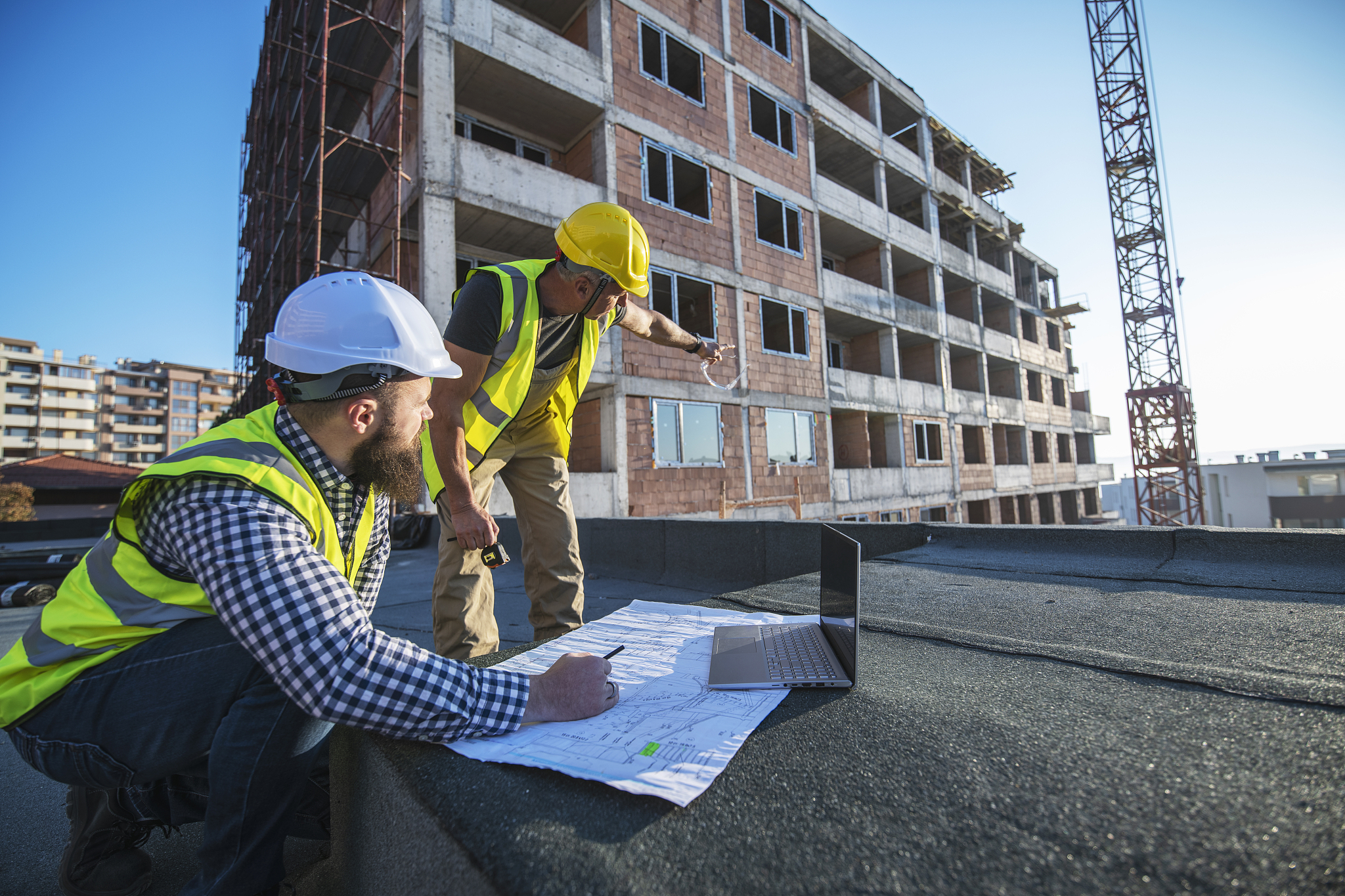 architects reviewing blueprints on construction site.