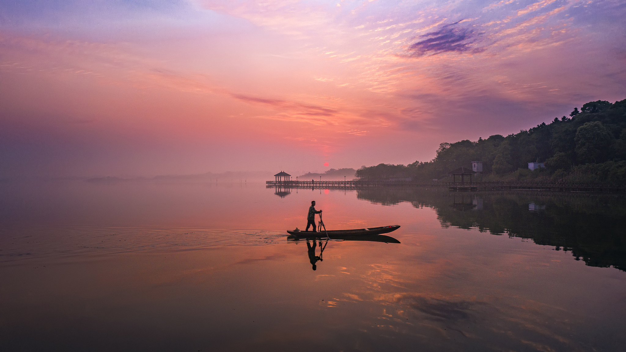 微山湖畔红日升雾气弥漫水中清。树影婆娑山色秀沛城村郭炊烟轻。渔舟缓缓湖中荡水鸟欢歌迎新生。村民相聚欢声笑田野风光无限好。最后一句改押韵